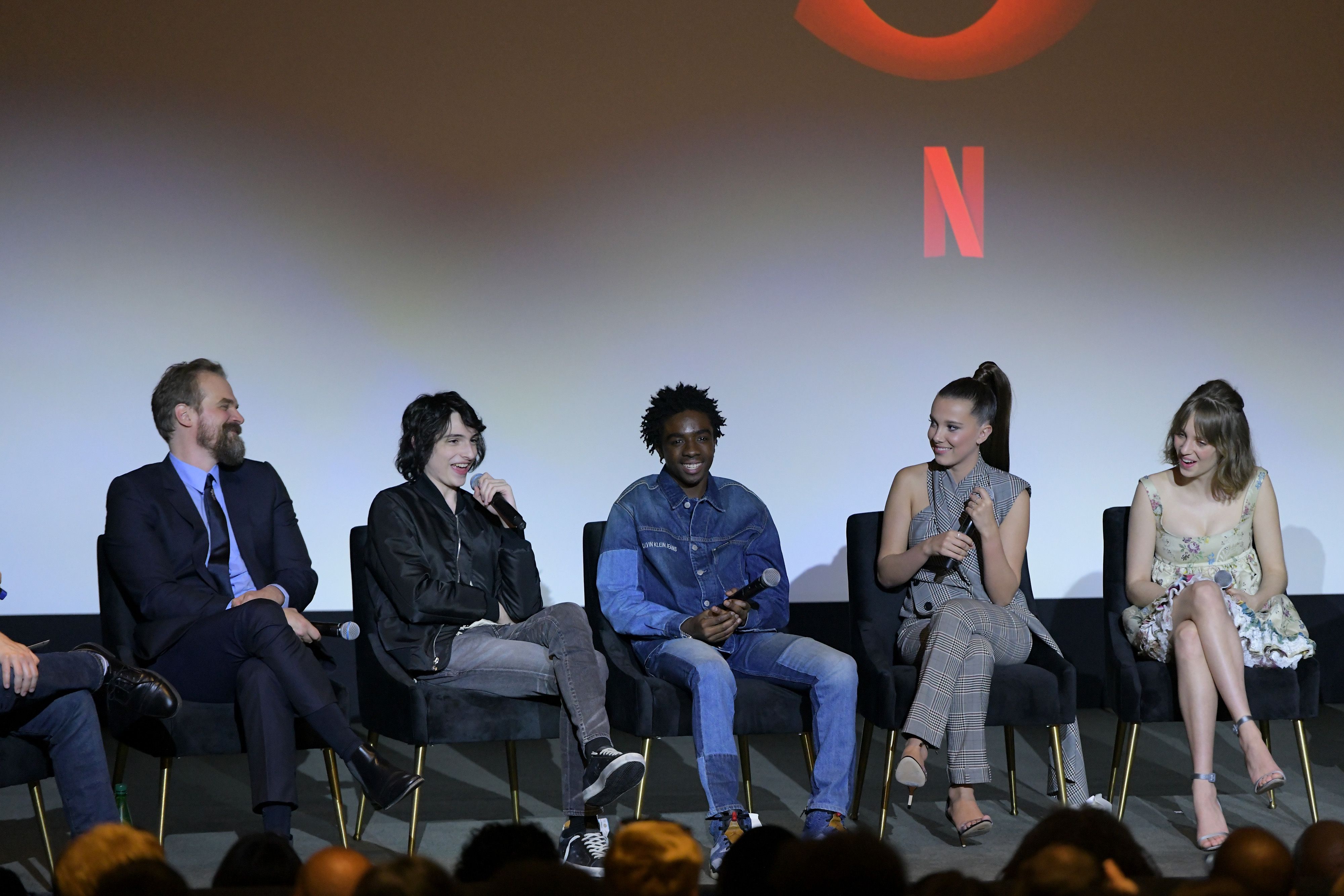 David Harbour, Finn Wolfhard, Caleb McLaughlin, Millie Bobby Brown, and Maya Hawke of Netflix's 'Stranger Things' sitting on stage