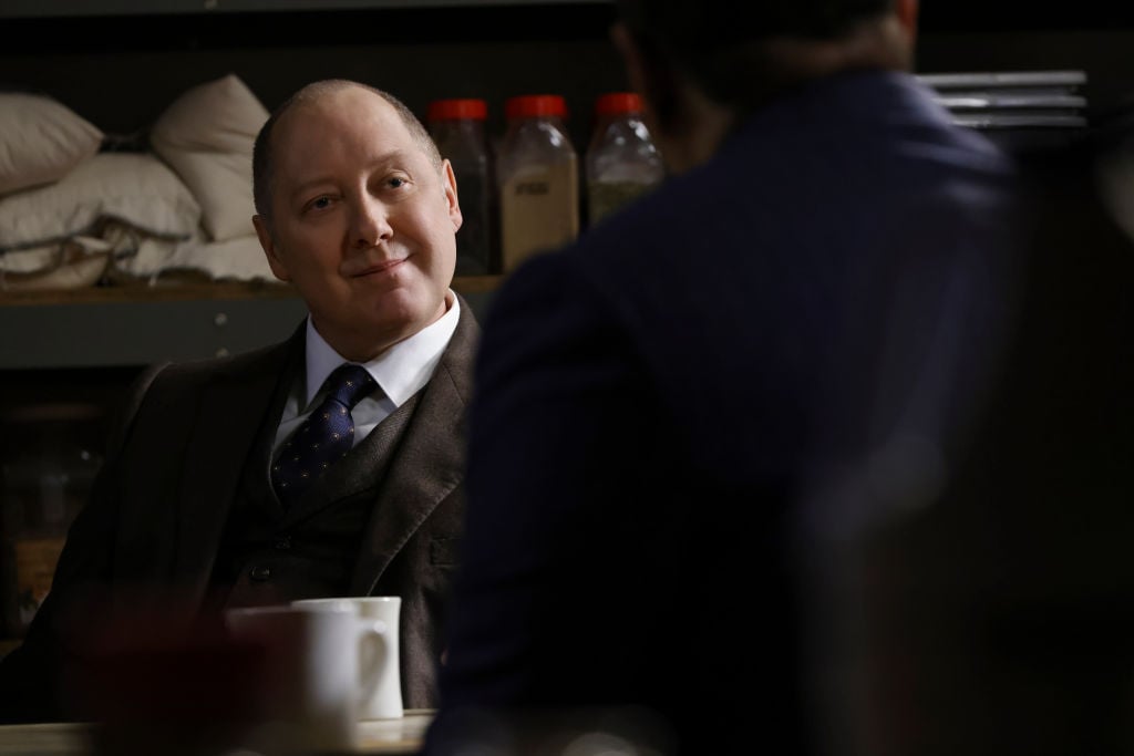 James Spader smiles while sitting in a chair as Raymond 'Red' Reddington on 'The Blacklist'