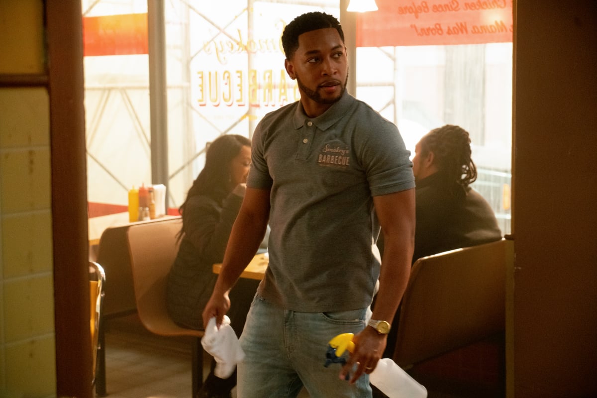 Jacob Latimore as Emmett standing in a restaurant in The Chi 
