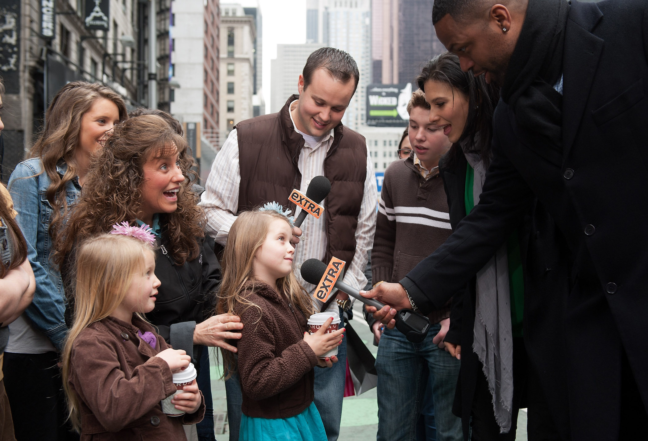 (R-L) AJ Calloway and Hilaria Baldwin interview the Duggar family outside during their visit with 'Extra'
