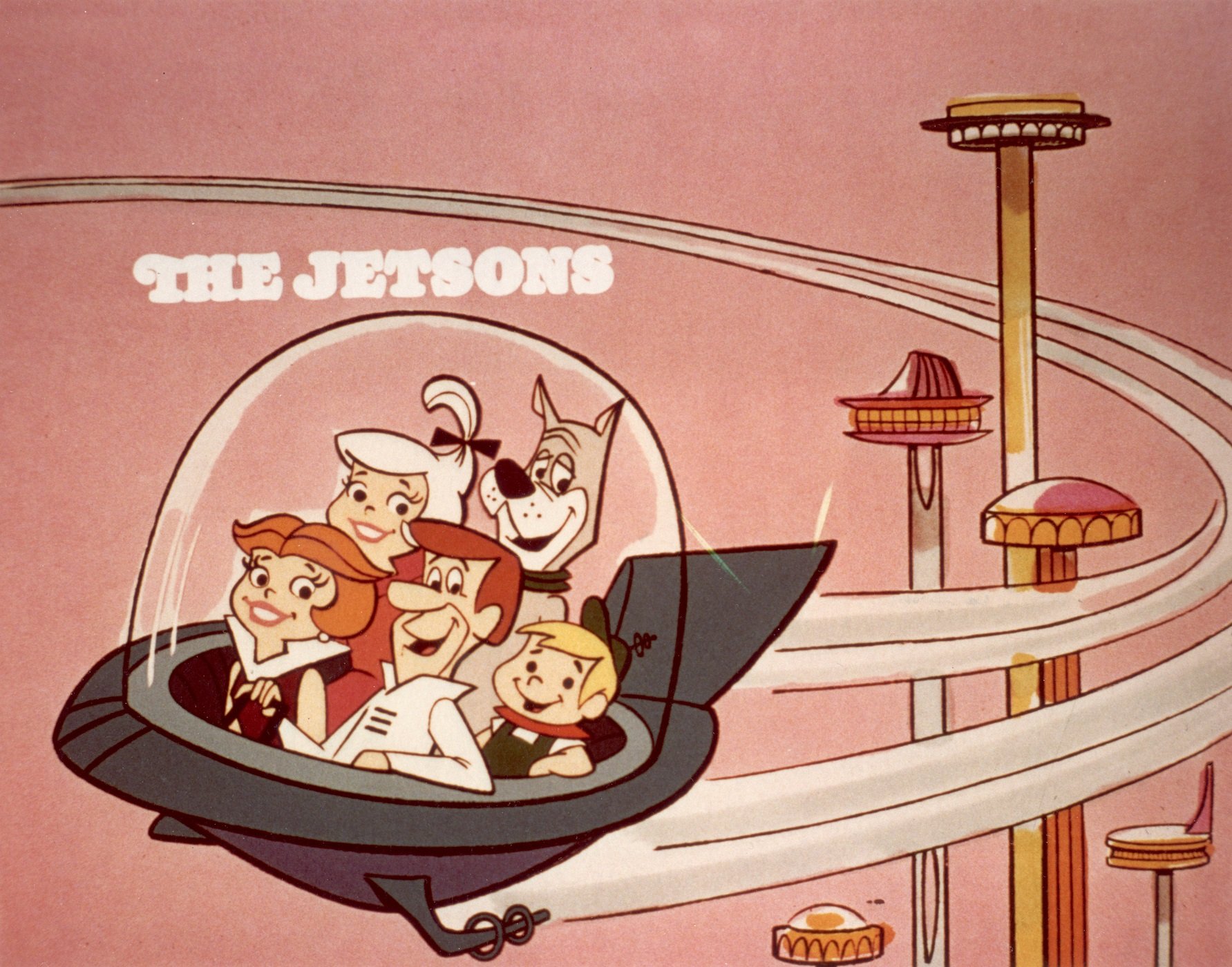 A still from 'The Jetsons' showing George, Jane, Judy, Elroy and Astro in the family's flying car. The family's fictional city is seen in the background