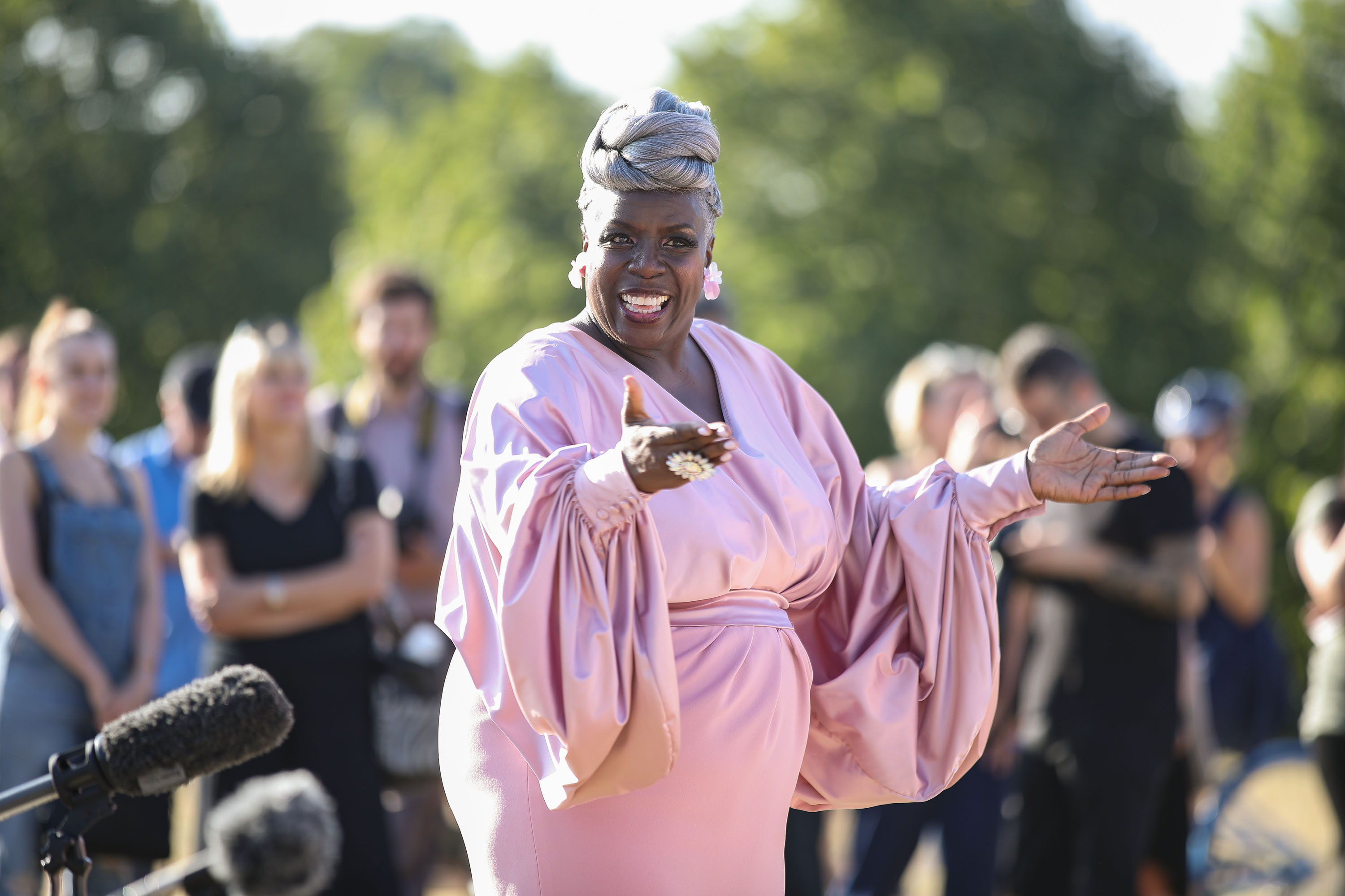 The Kingdom Choir conductor Karen Gibson in a pink outfit performing outside Kensington Palace