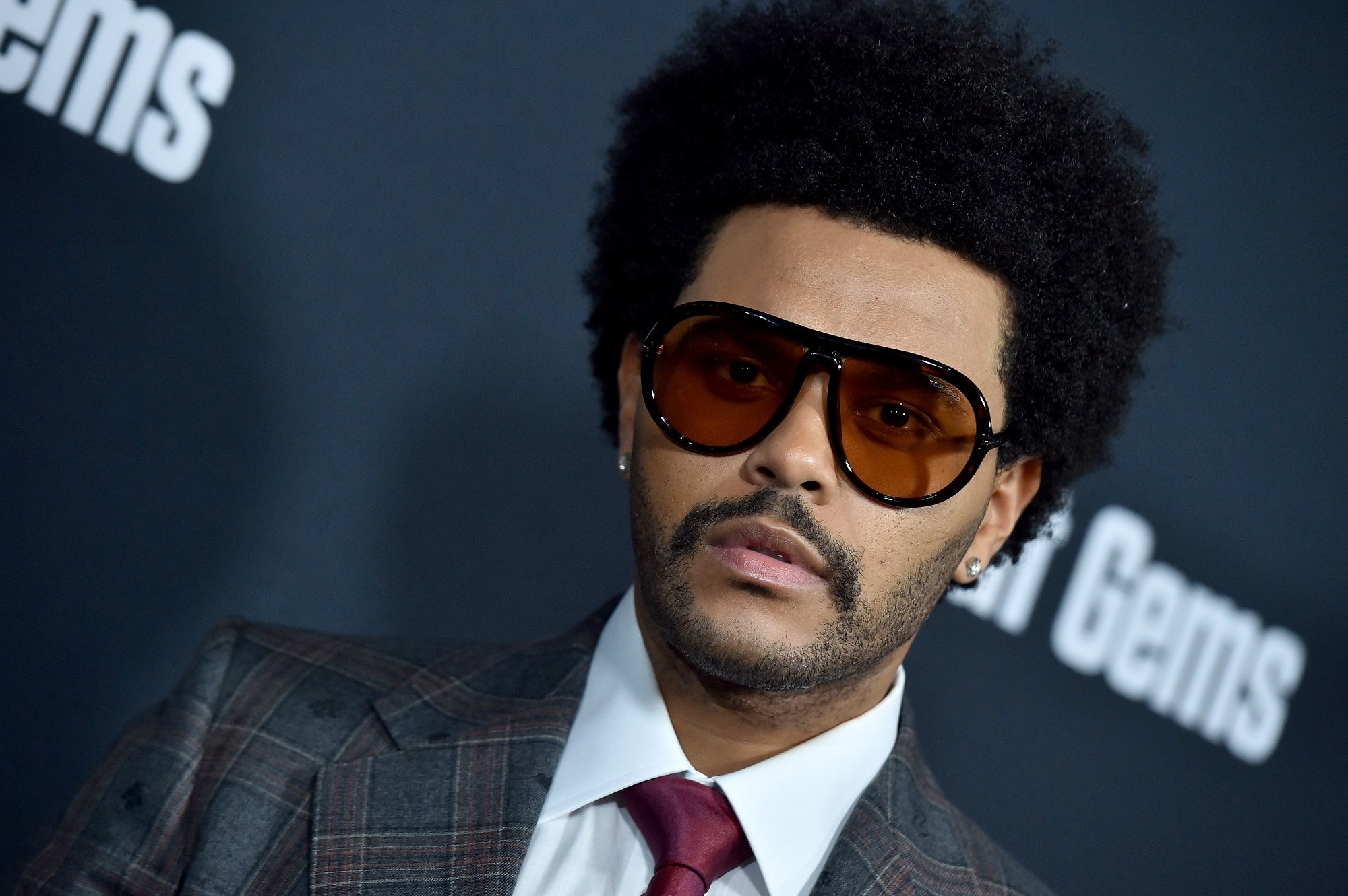 The Weeknd wearing sunglasses and a suit at the premiere of A24's 'Uncut Gems'