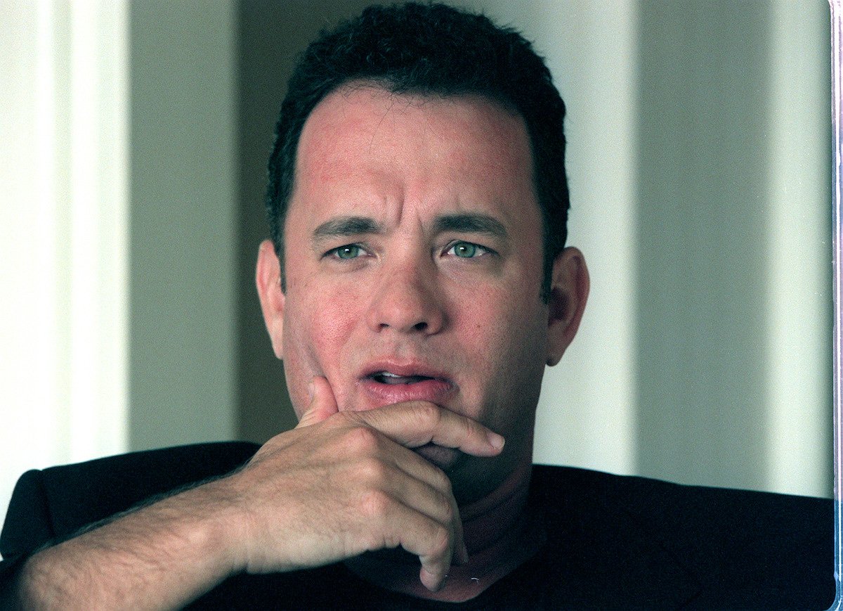 Tom Hanks rests his head on his hand thoughtfully during a Q&A session