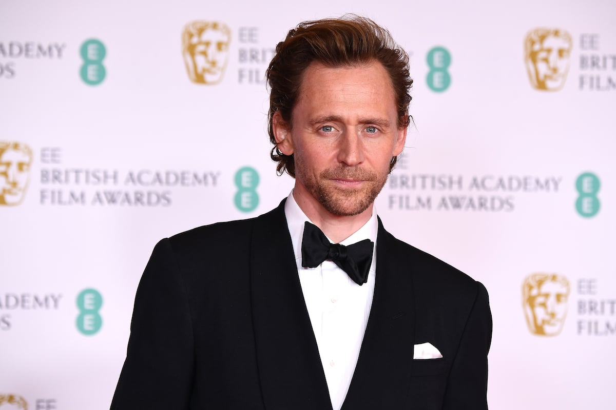 Tom Hiddleston wears a suit and poses at the EE British Academy Film Awards 2021