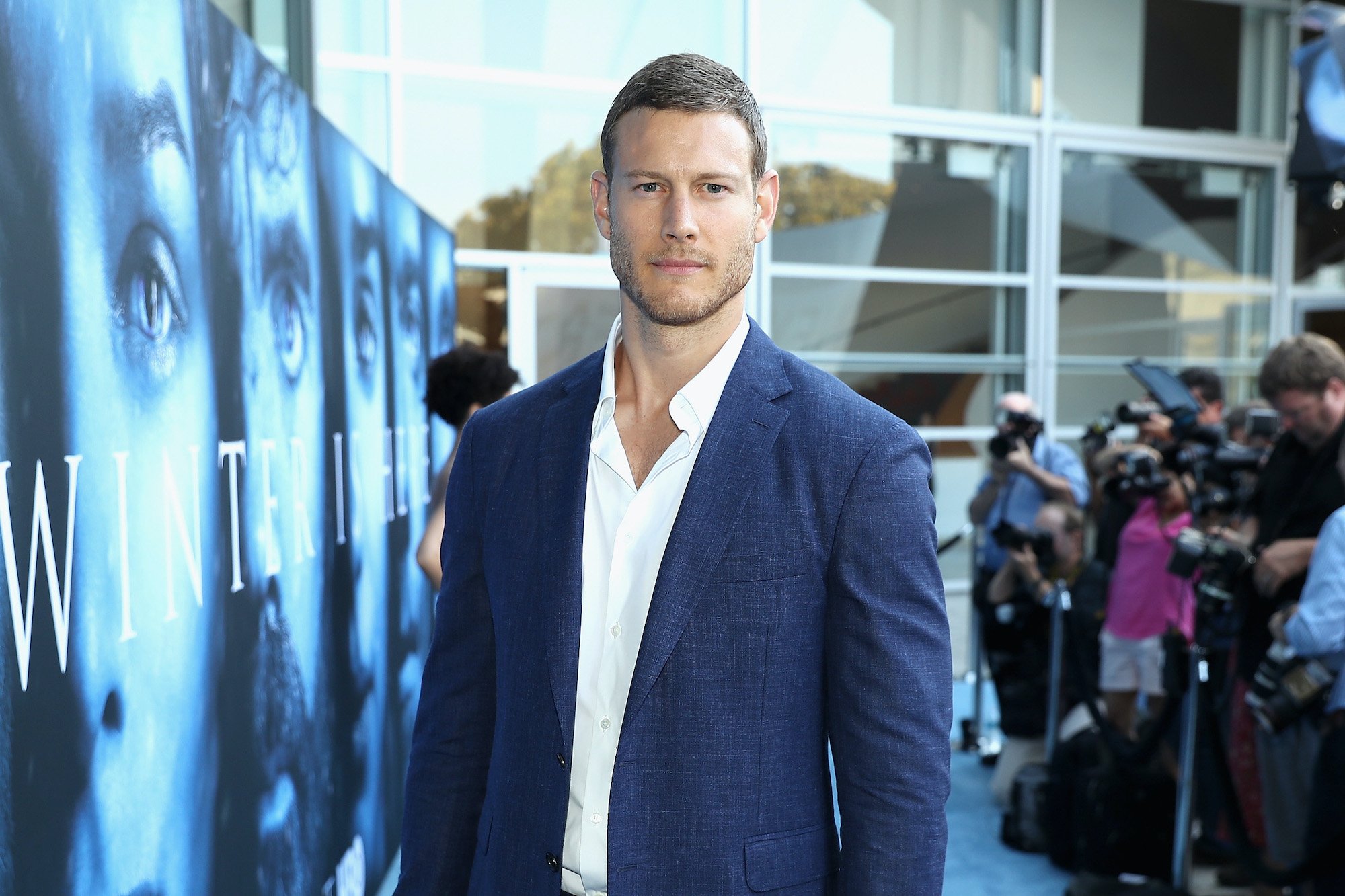 Tom Hopper smiling on a red carpet