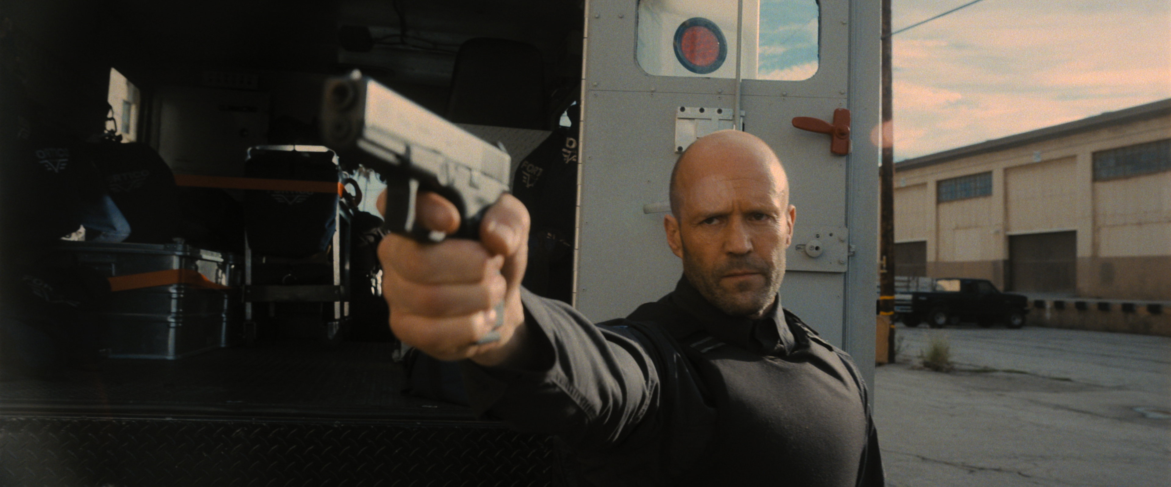 Wrath of Man star Jason Statham points a gun