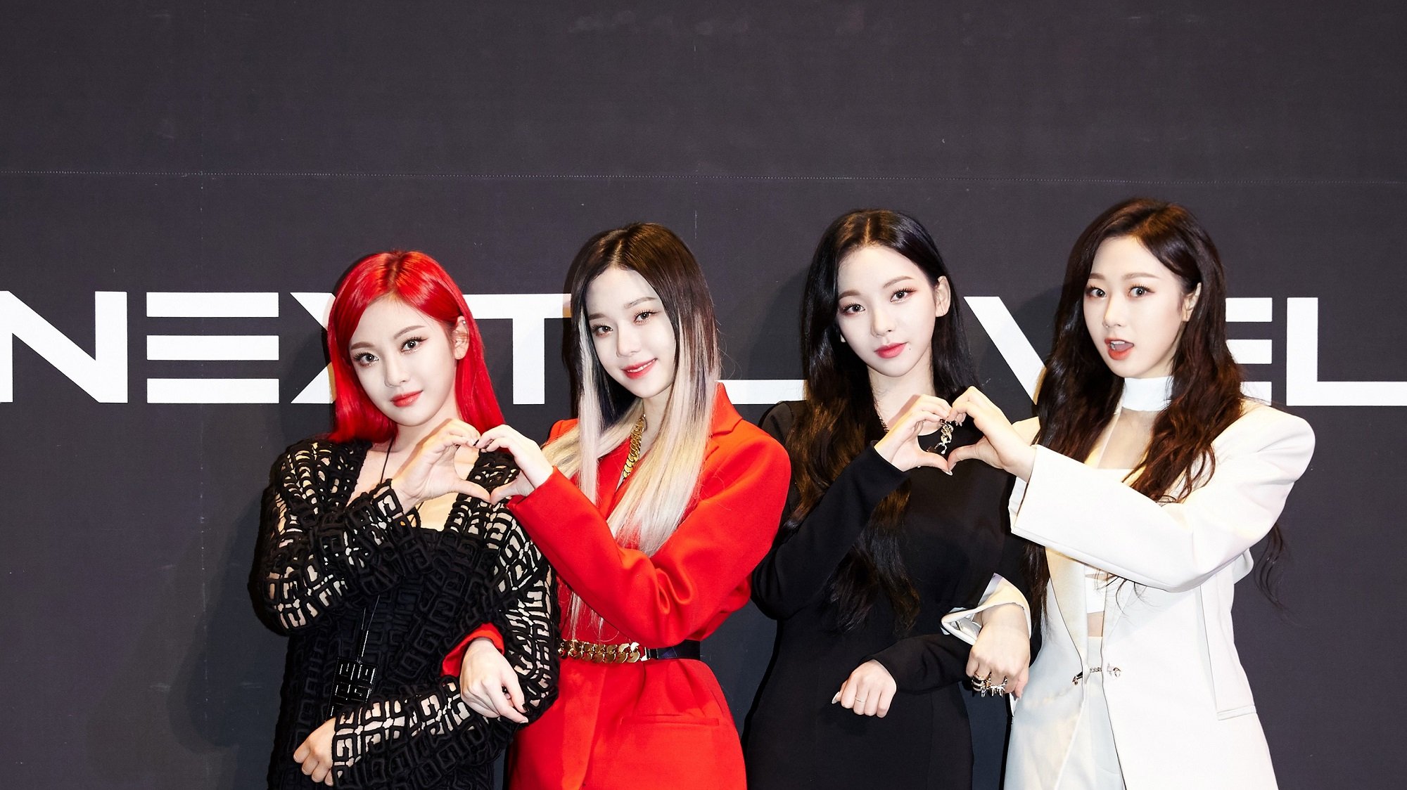 The members of aespa pose at a press conference for the K-pop group's single 'Next Level'
