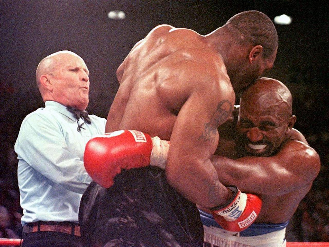 Referee Lane Mills (L) steps in as Evander Holyfield (R) reacts after Mike Tyson bit his ear in the third round of their WBA heavyweight championship fight