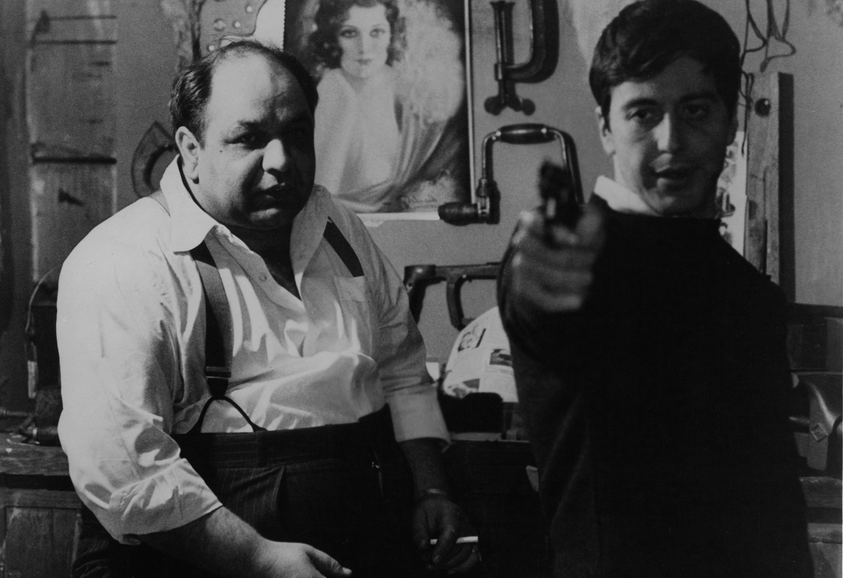 Al Pacino points a pistol as Richard Castellano looks on a scene from 'The Godfather.'
