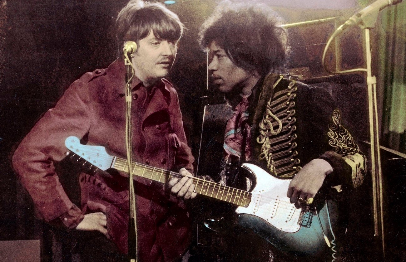 Chas Chandler and Jimi Hendrix confer on stage.