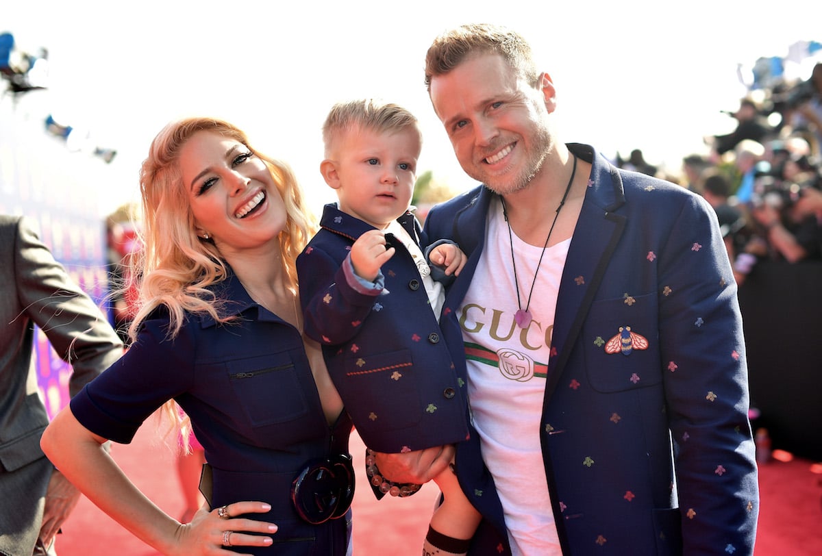 Spencer Pratt holding his son and standing next to Heidi Montag
