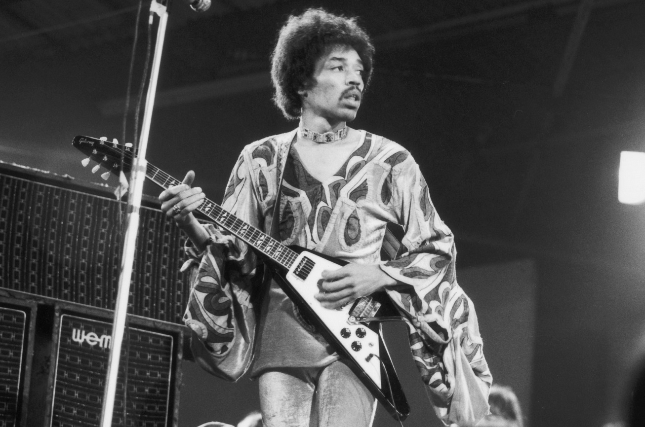 Jimi Hendrix looks across the stage while playing guitar at a 1970 show