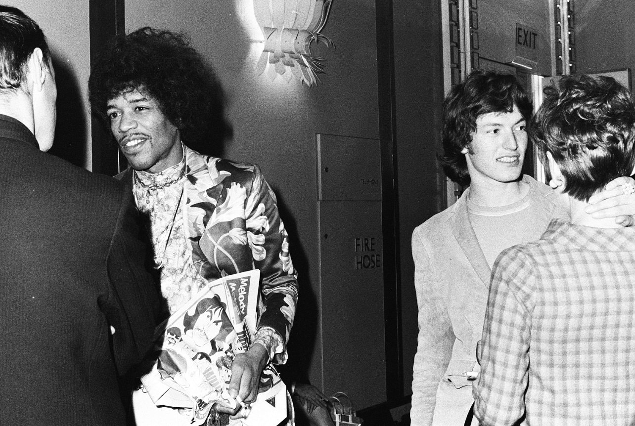 Jimi Hendrix and Steve Winwood smile as they talk with people at an award reception