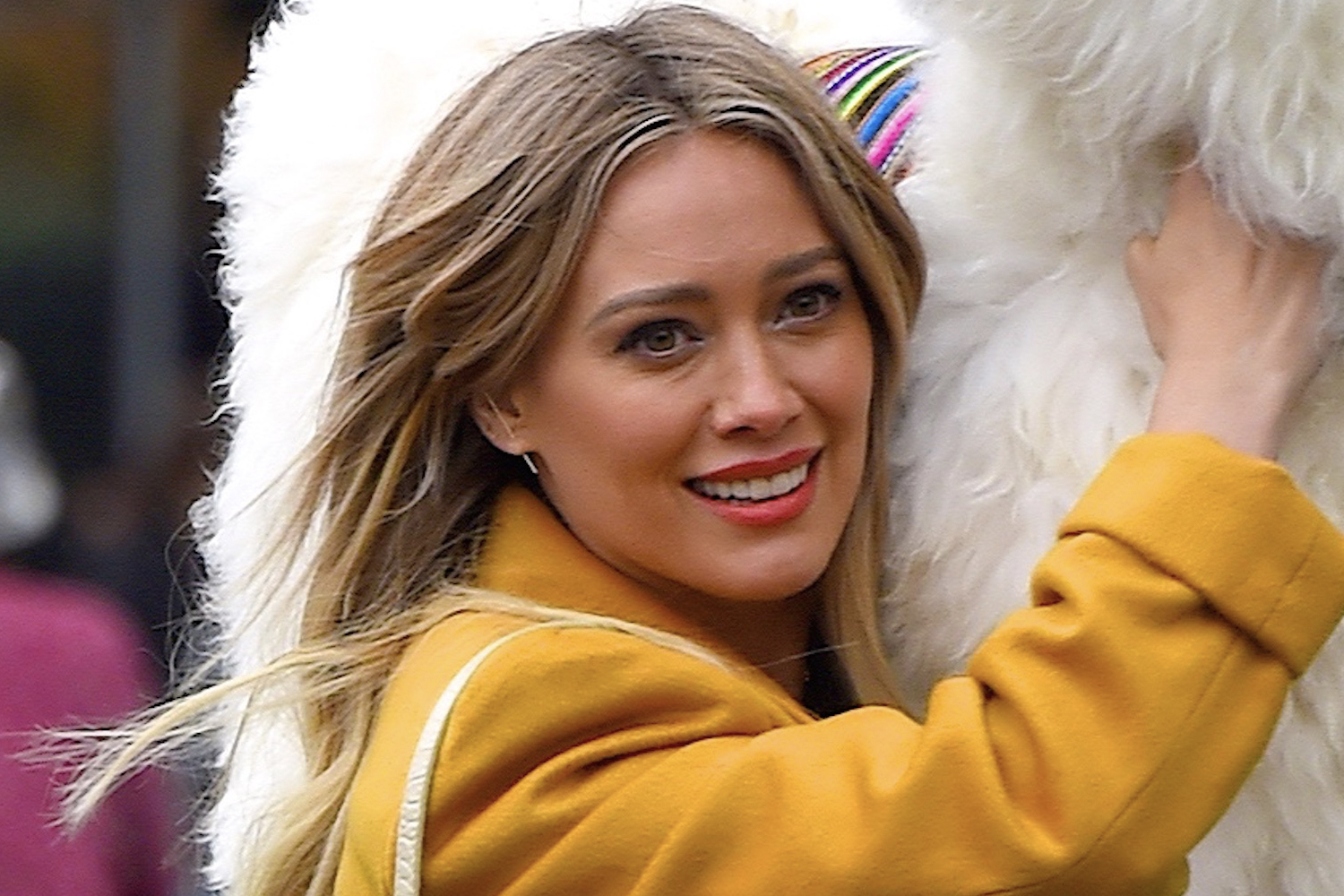 Hilary Duff carrying a llama while shooting an episode of the Lizzie McGuire reboot in 2019