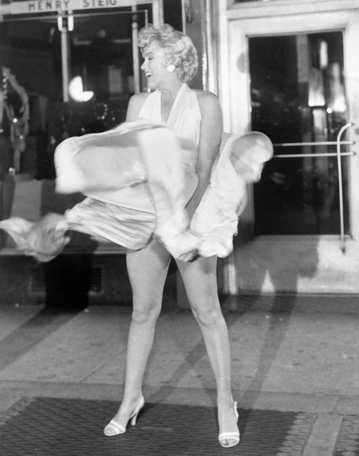 Actress Marilyn Monroe tries to hold down her dress as wind from a subway grate blows it upward