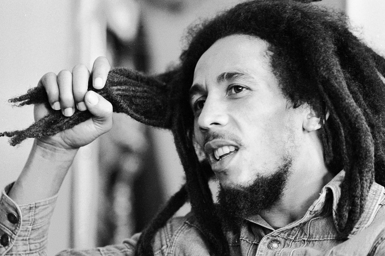 Bob Marley holds his dreadlocks as he speaks to an interviewer in 1978.