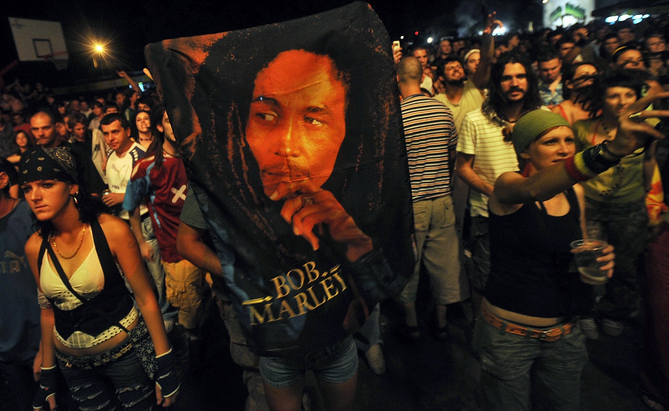 Serbian villagers hold a Bob Marley blanket while attending the unveiling of a Marley statue.