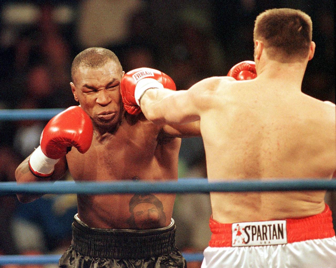 Mike Tyson (L) and Andrew Golota trade punches during the second round of their fight