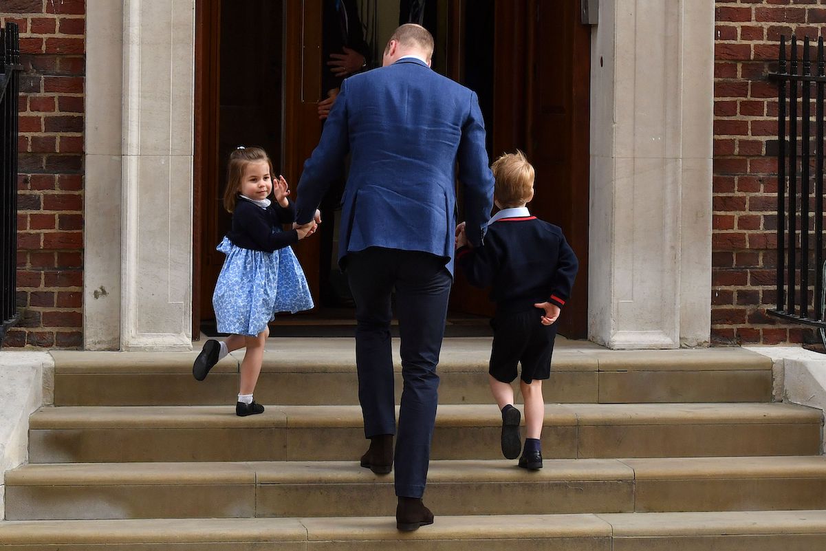 Princess Charlotte turns and waves to the crowd as she prepares to meet Prince Louis in 2018