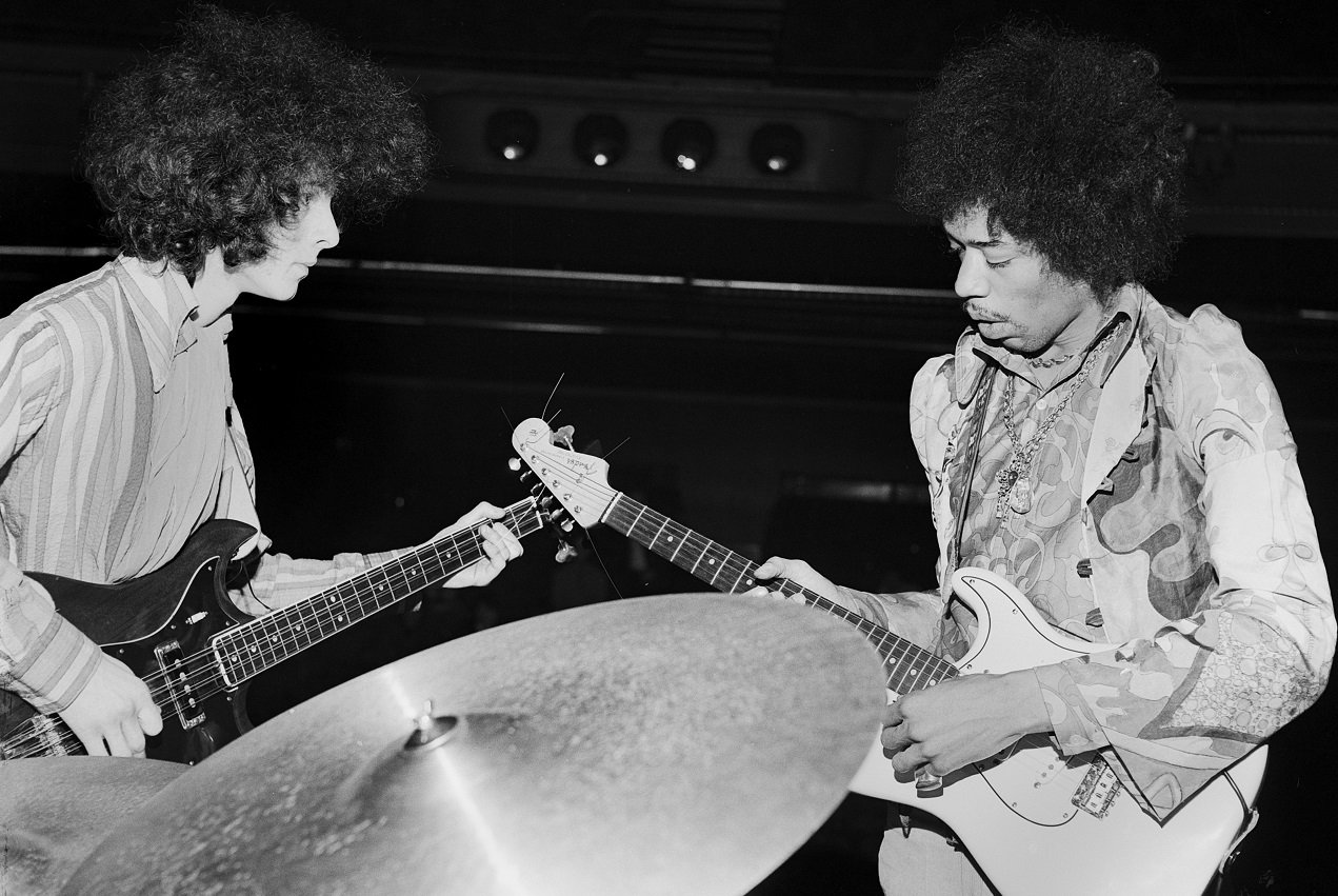 Noel Redding and Jimi Hendrix tune their guitars on stage in 1967.