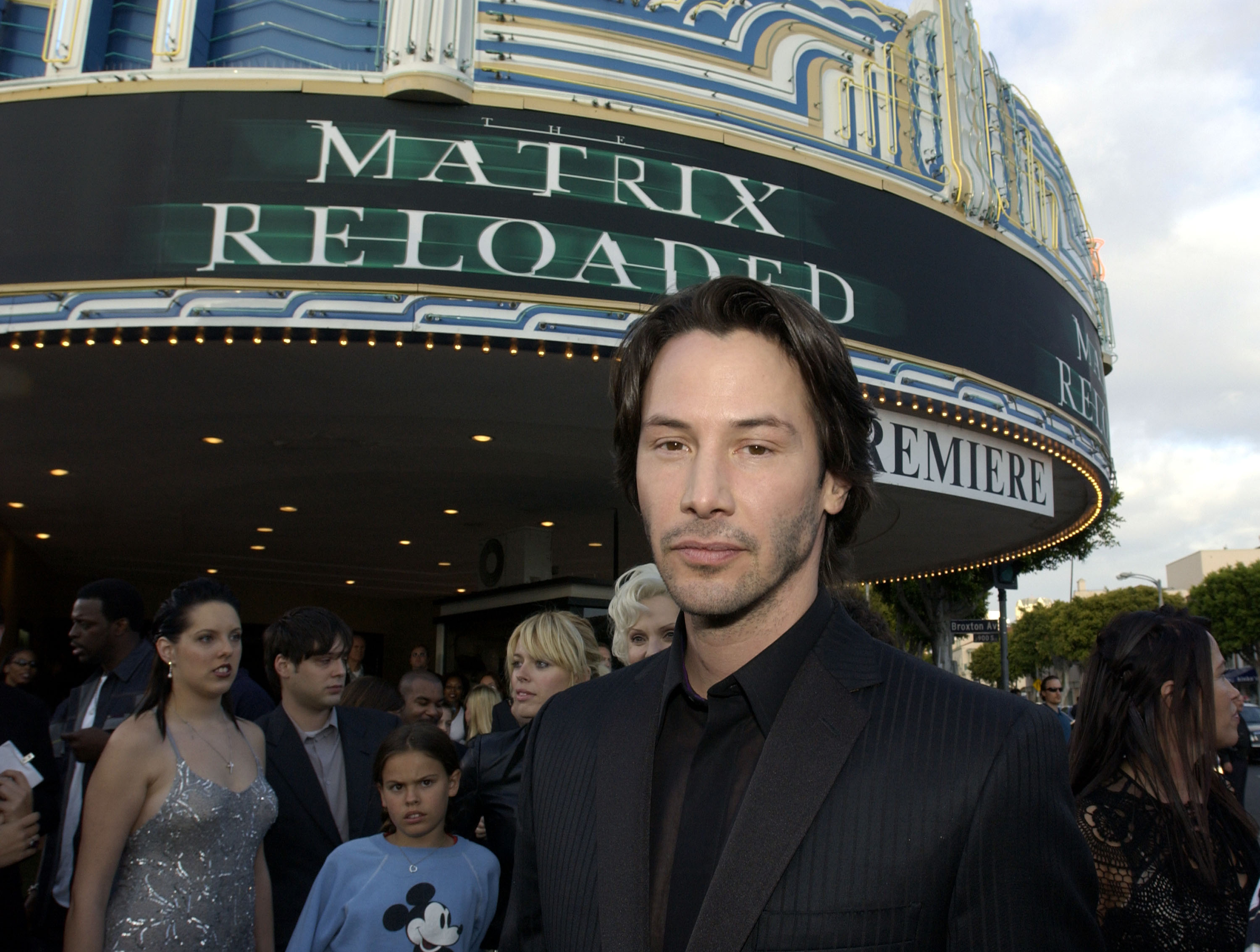 Keanu Reeves near a marquee advertising The Matrix Reloaded