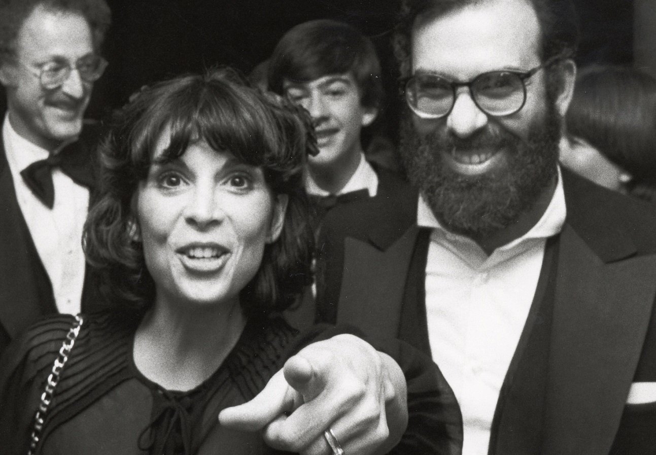 Talia Shire points at the camera and smiles and Francis Ford Coppola laughs.