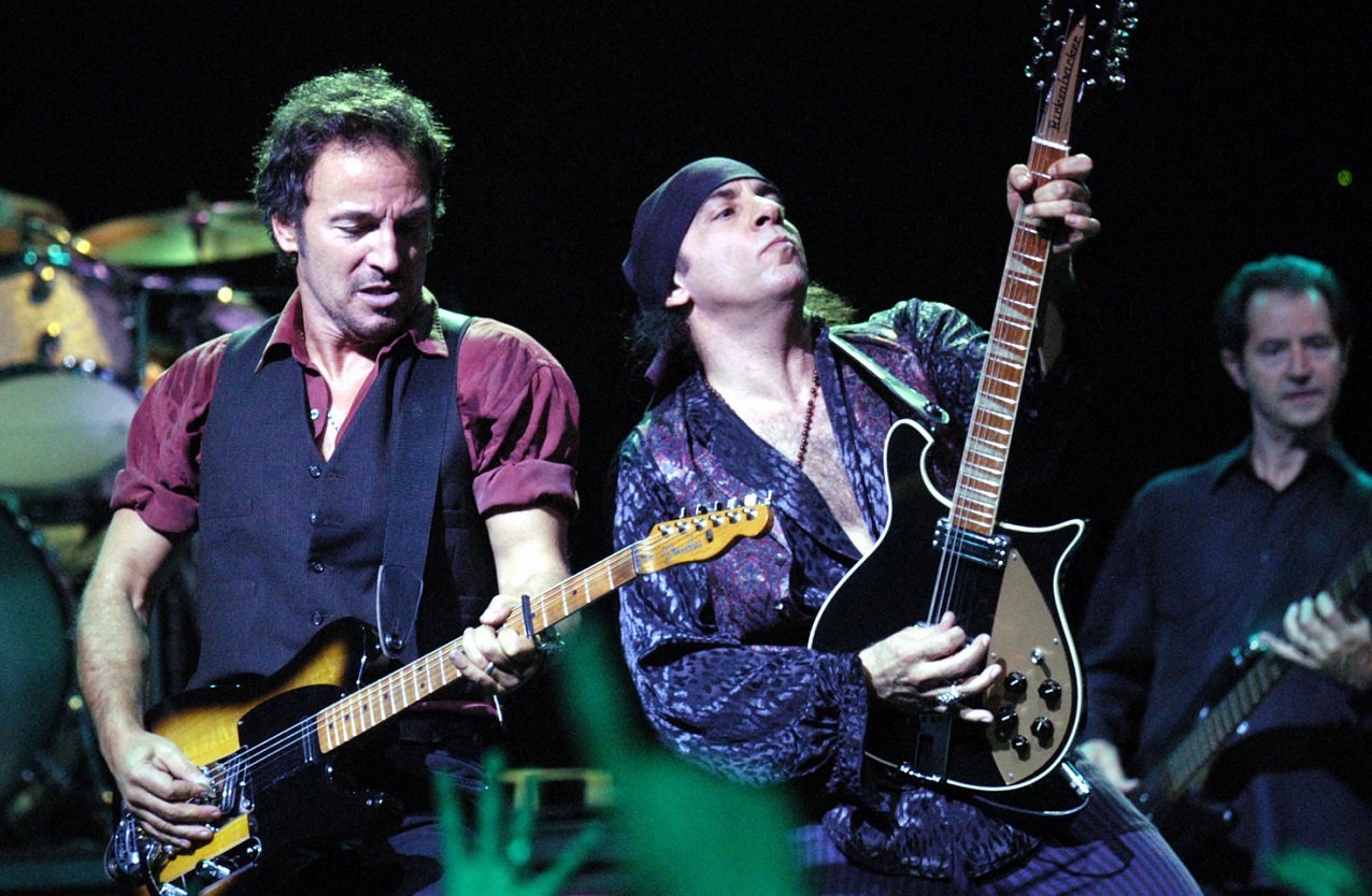 Bruce Springsteen and Steven Van Zandt play guitar side-by-side on stage in an early 2000s E Street Band performance.