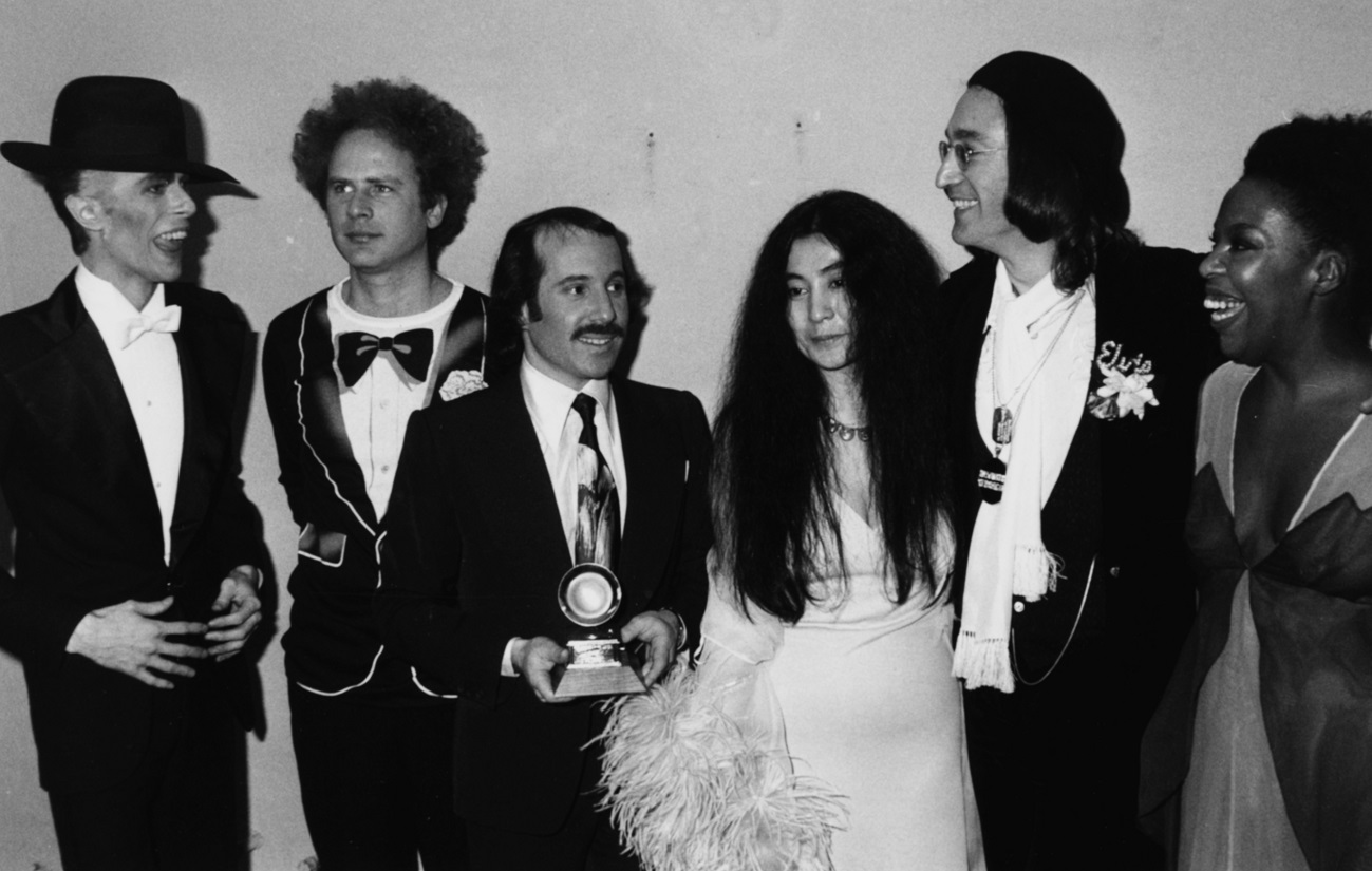 David Bowie, Art Garfunkel, Paul Simon, Yoko Ono, John Lennon, and Roberta Flack pose together at the Grammy Awards, March 1975.