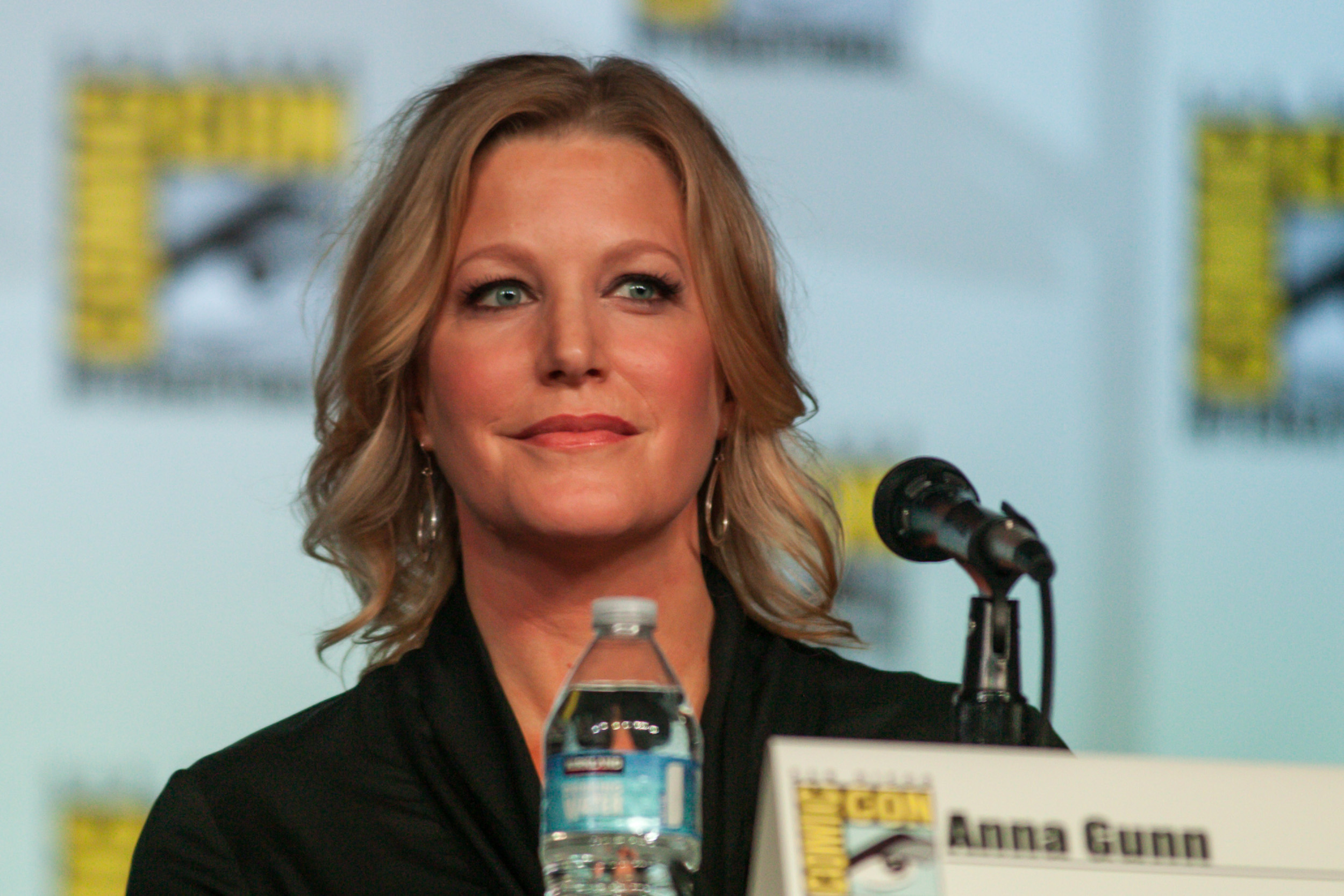 Anna Gunn sitting in front of a microphone during a Comic-Con panel