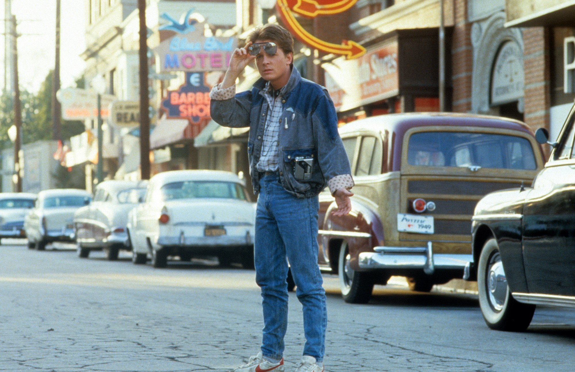 Michael J Fox walking across the street in a scene from 'Back To The Future