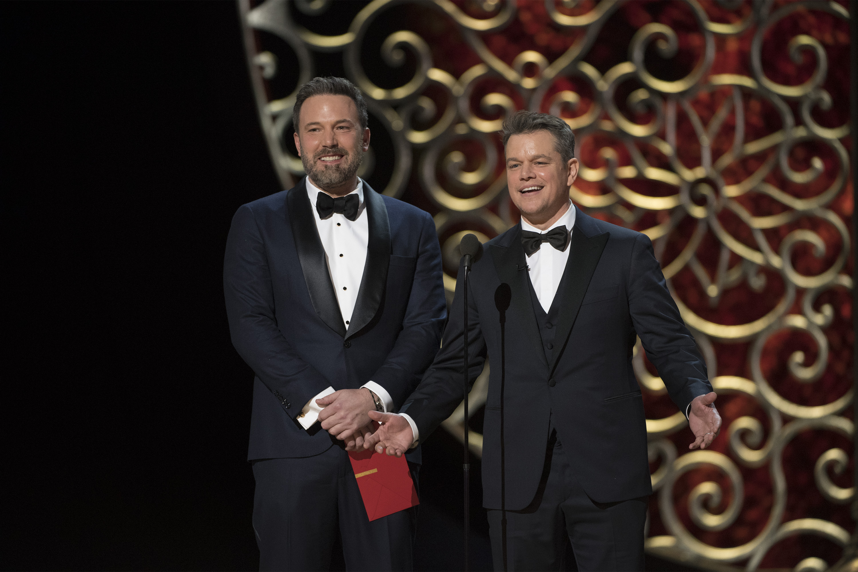 Ben Affleck and Matt Damon onstage together presenting an award at 89th Oscars
