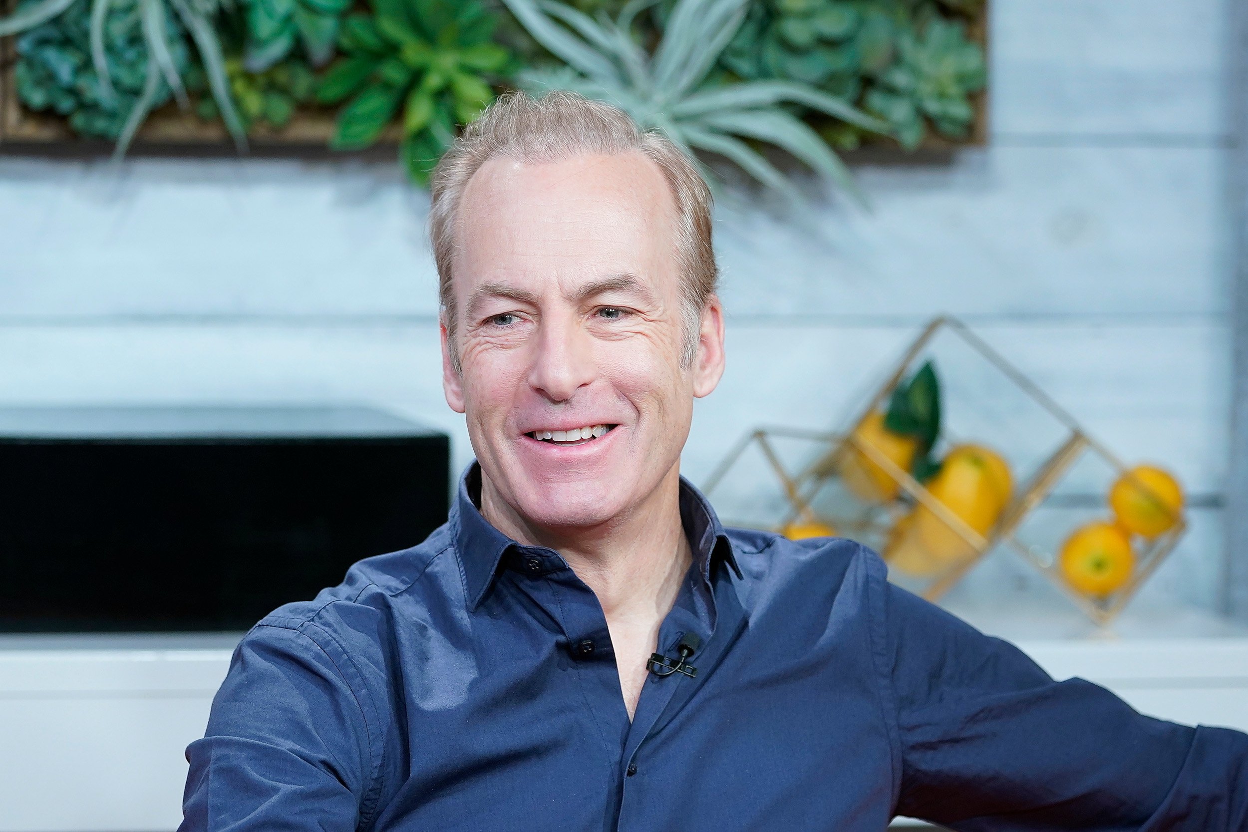 Bob Odenkirk wearing a blue button-up shirt and smiling