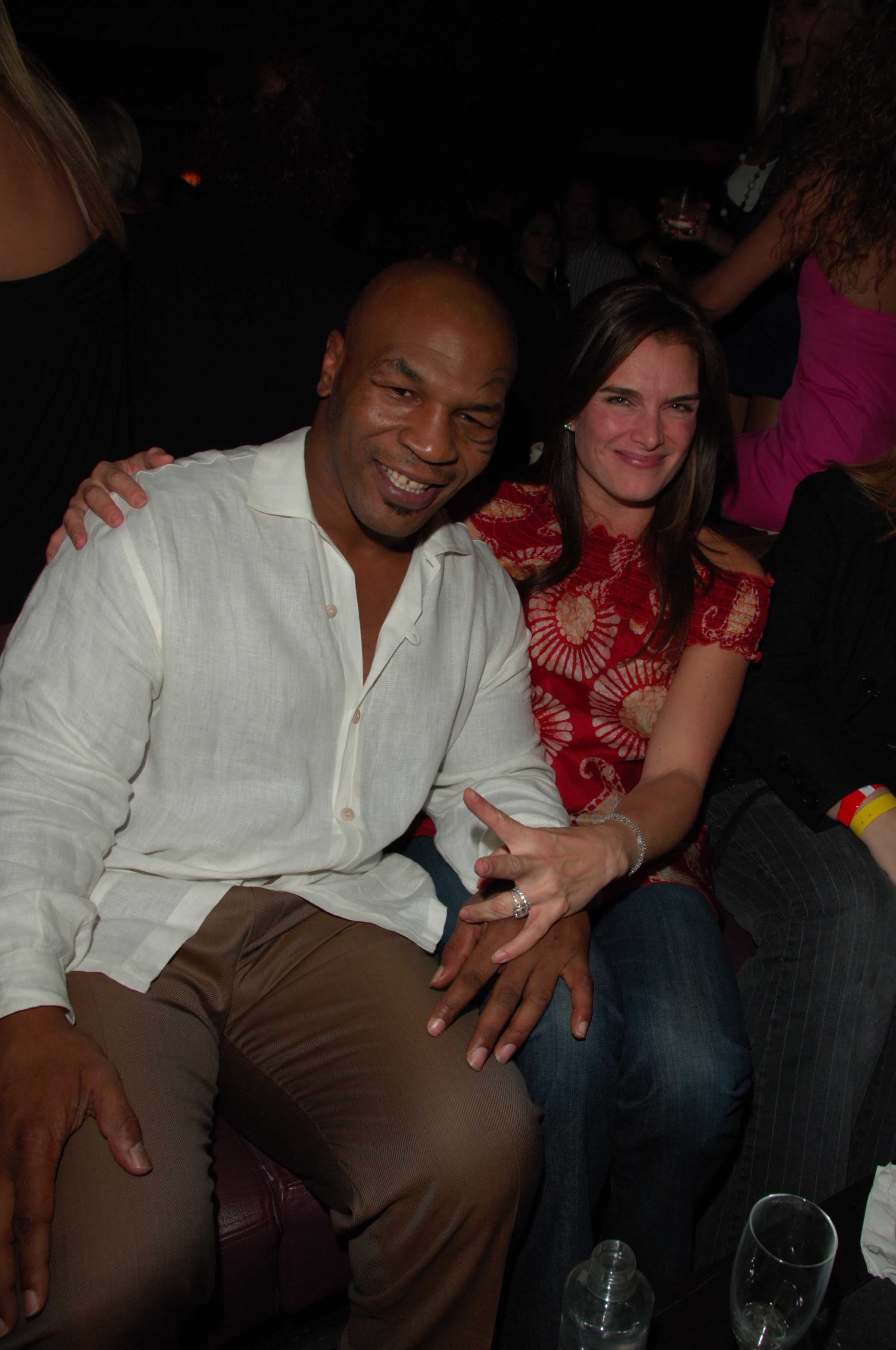 Brooke Shields sitting next to Mike Tyson with her arm around his shoulder at the TAO Las Vegas anniversary party in 2006