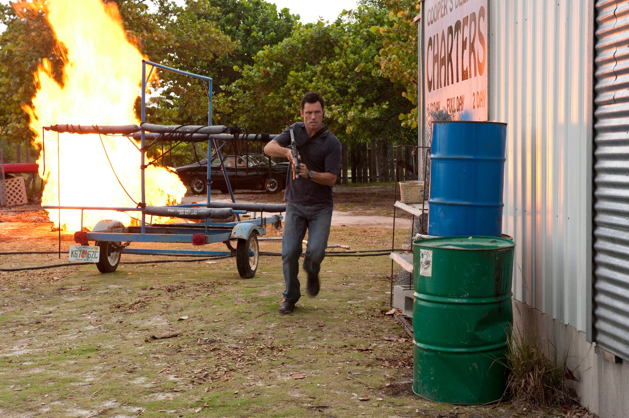 Jeffrey Donovan on 'Burn Notice' running around with a fire in the background