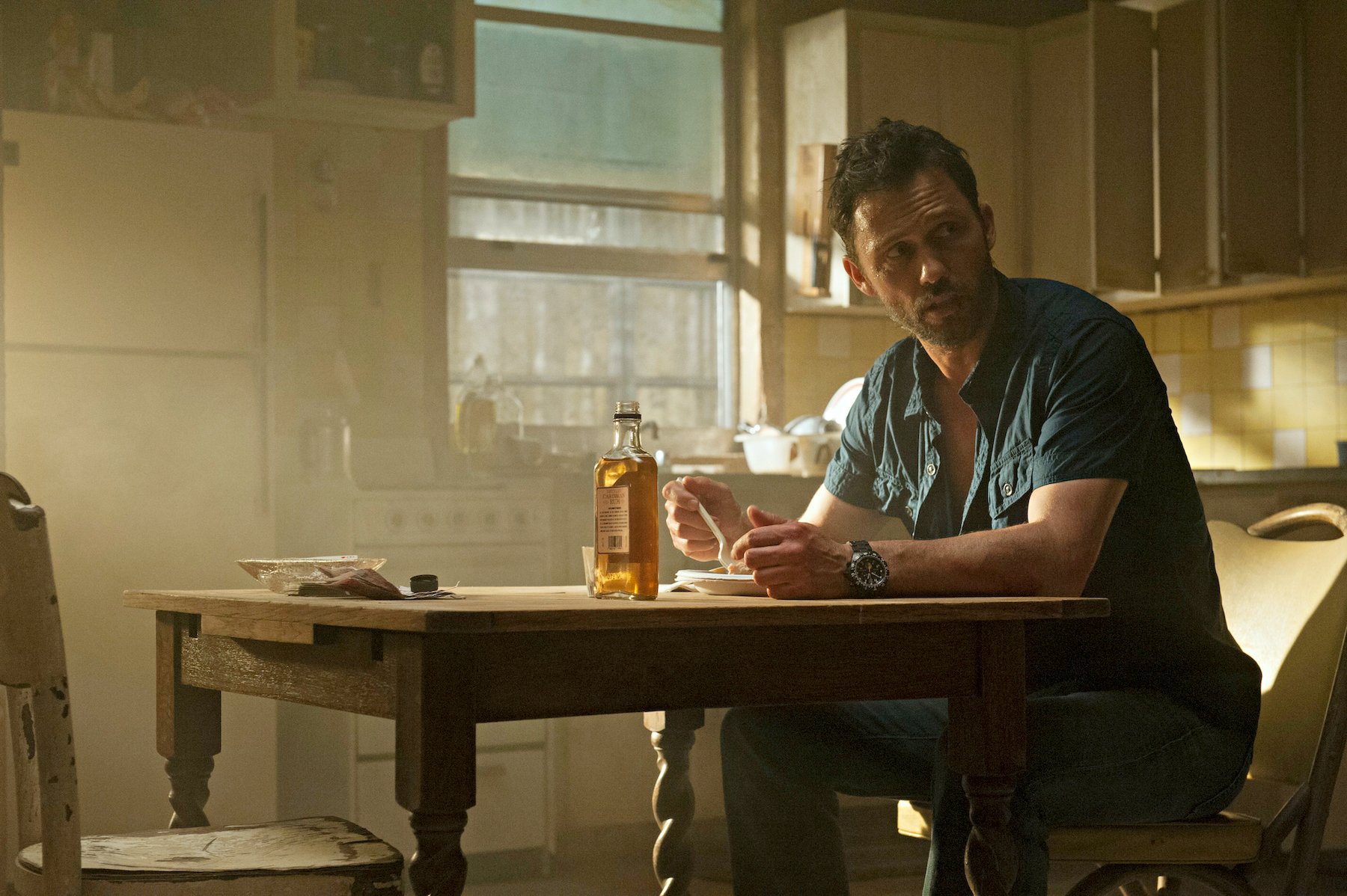 Jeffrey Donovan sitting at a table in a scene from 'Burn Notice'