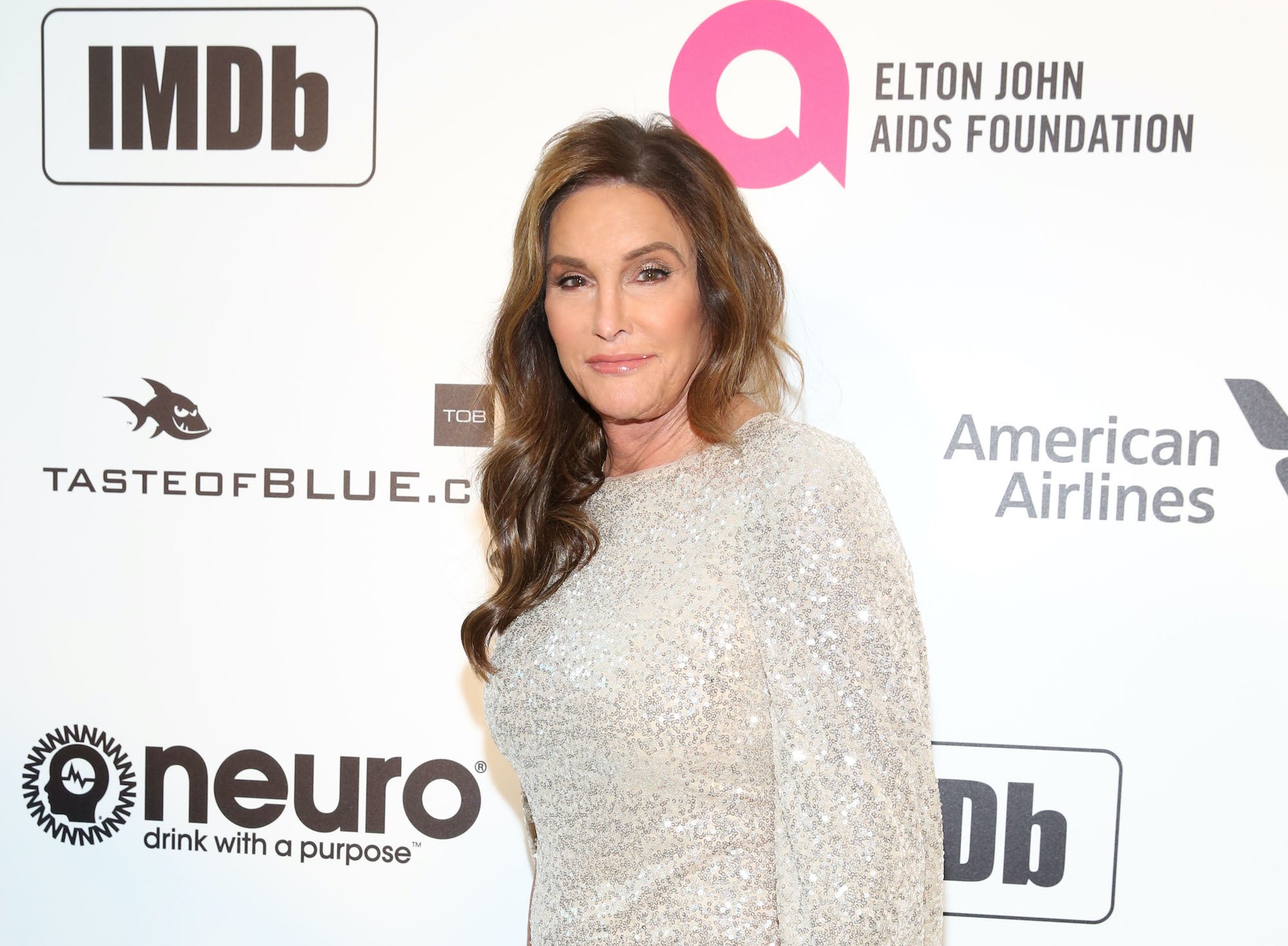 Caitlyn Jenner smiling in front of a white background