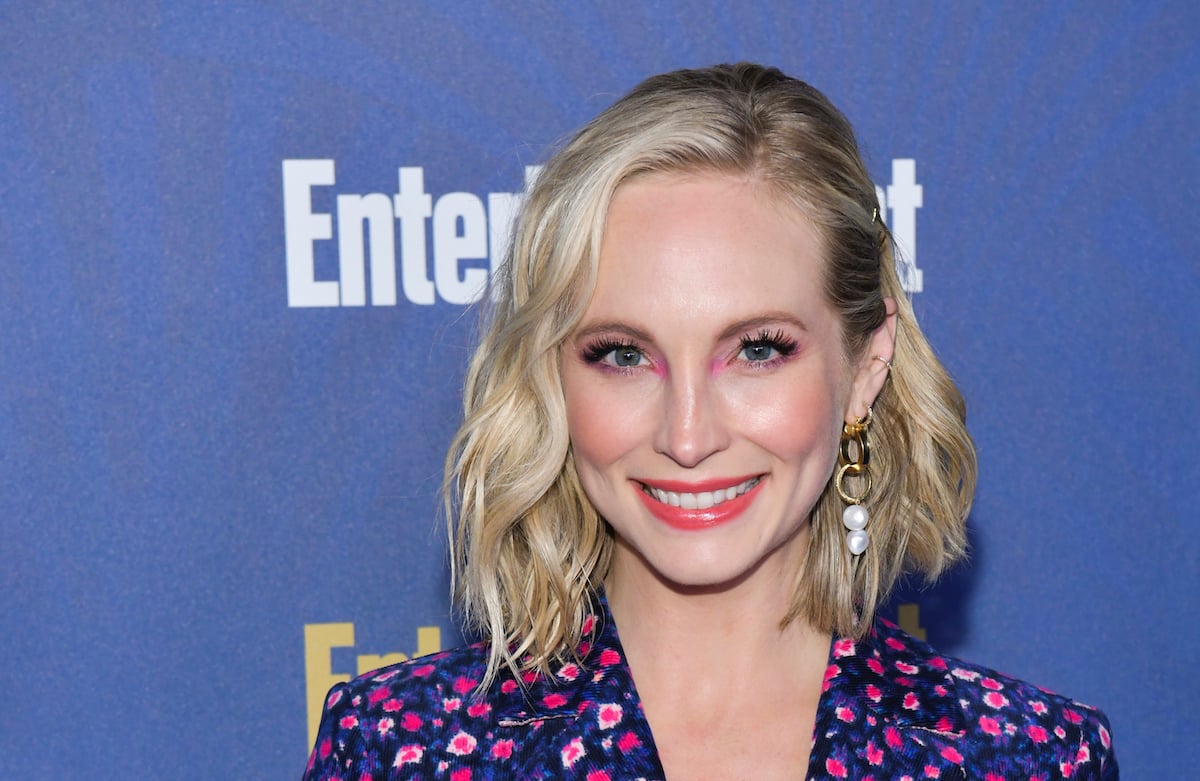 Candice King smiles while wearing colorful makeup on the red carpet.