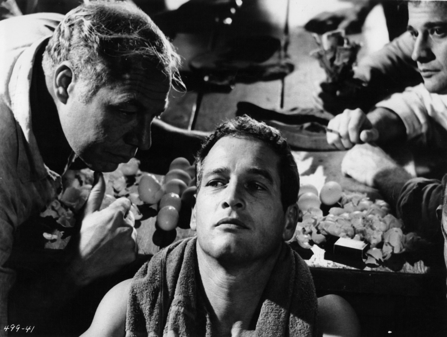 George Kennedy leaning into Paul Newman in a scene from the film 'Cool Hand Luke'