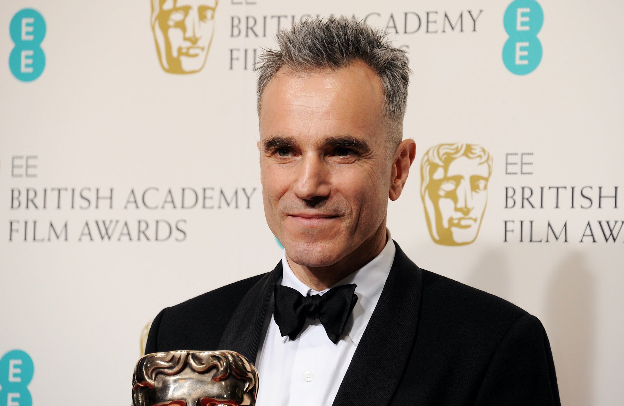 Daniel Day-Lewis smiling in front of a white background