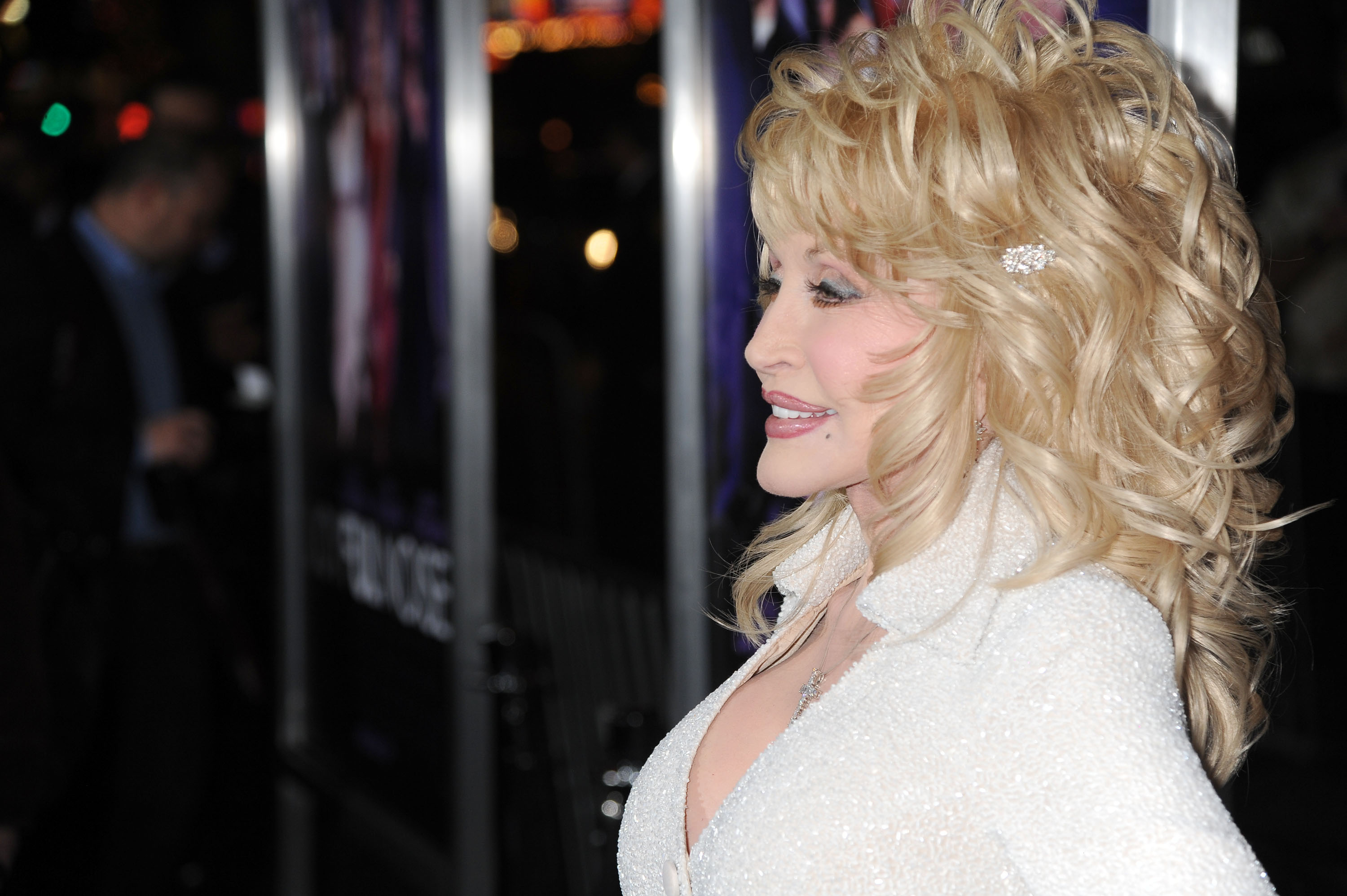 Dolly Parton poses for photos at the 'Joyful noise' premiere. She's in a white top.