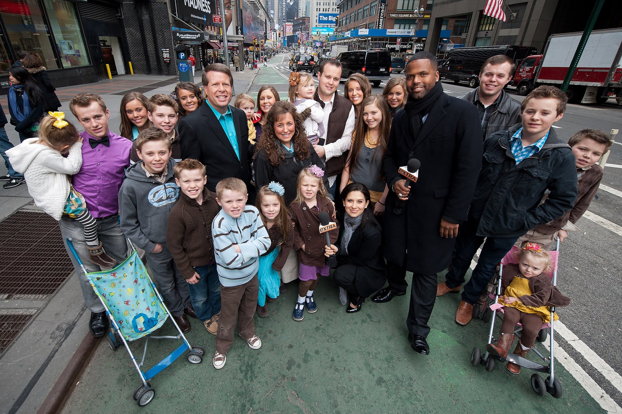 The Duggar family standing and posing for a photo outside for the news