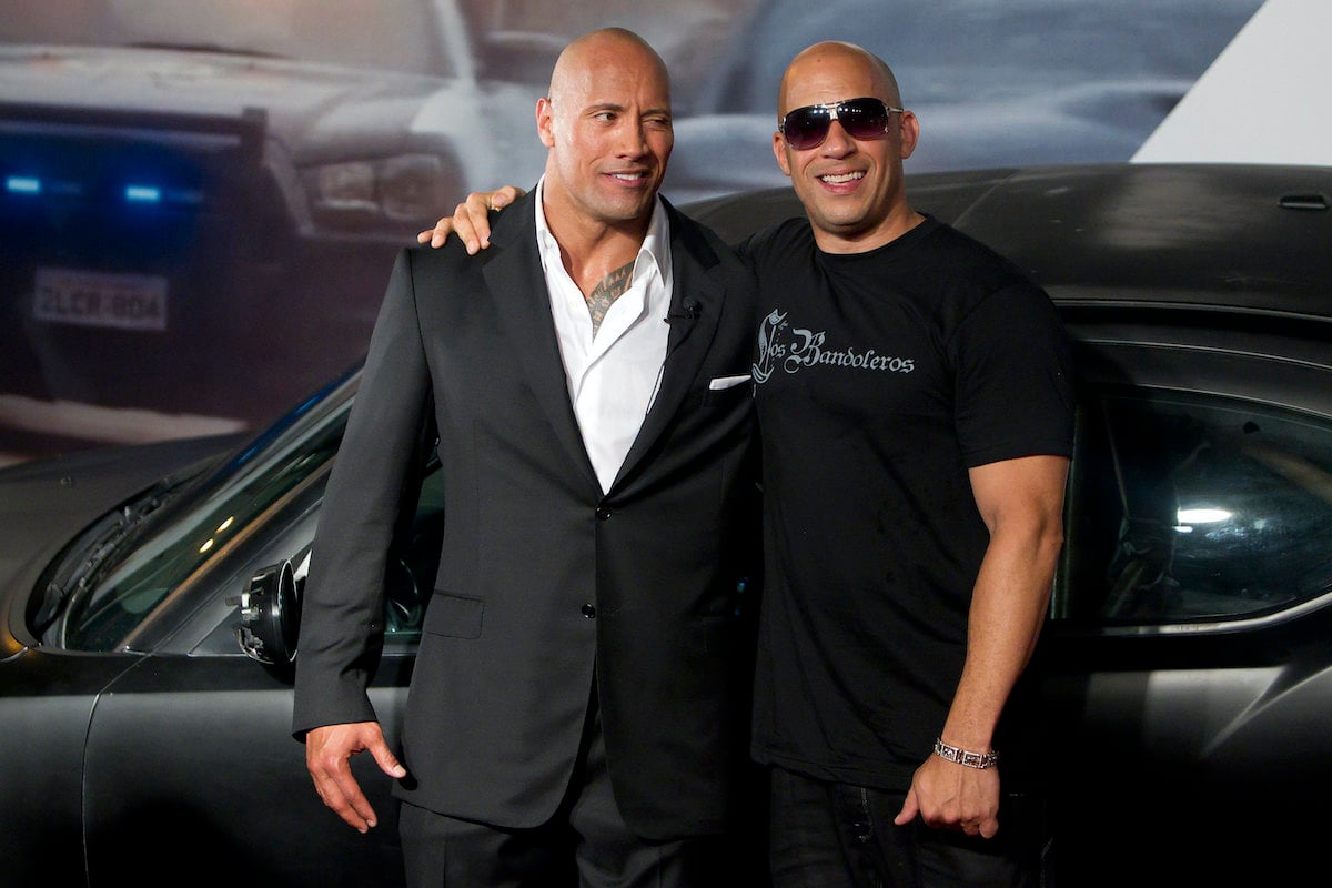 ‘Fast Five’ co-stars Dwayne Johnson and Vin Diesel pose in front of a black car