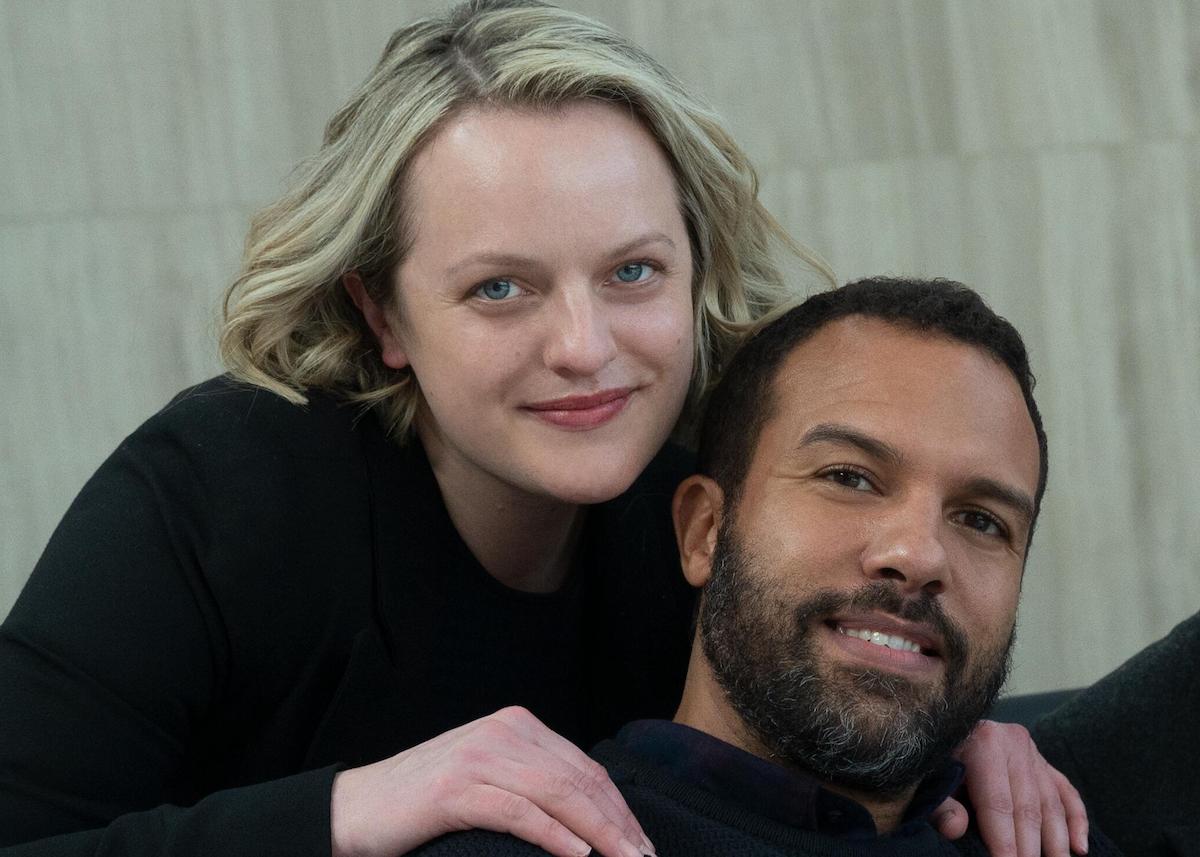 Elisabeth Moss and O-T Fagbenle pose and smile for a photo on set of 'The Handmaid's Tale' Season 4 Episode 8, 'Testimony'. Both are wearing black. Moss rests her hands on Fagbenle's shoulders.