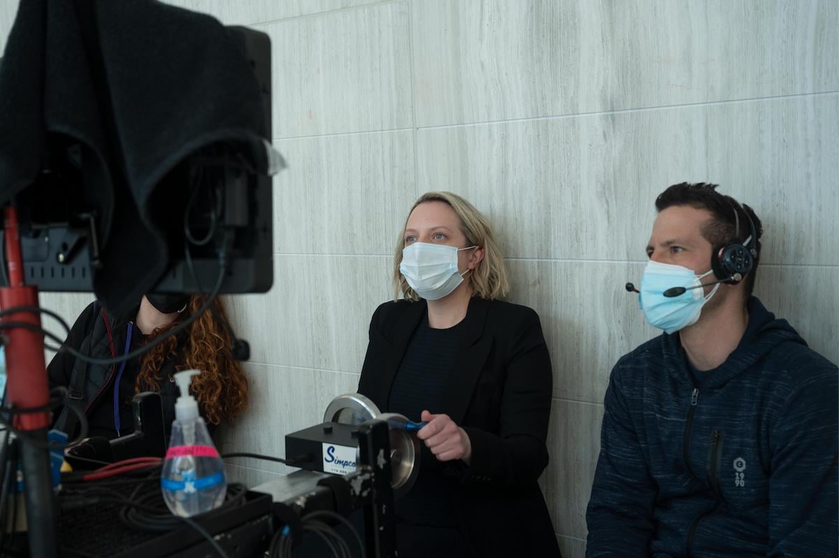 Elisabeth Moss watches playback while wearing a black suit and white mask on set of 'The Handmaid's Tale' Season 4 Episode 8, 'Testimony'
