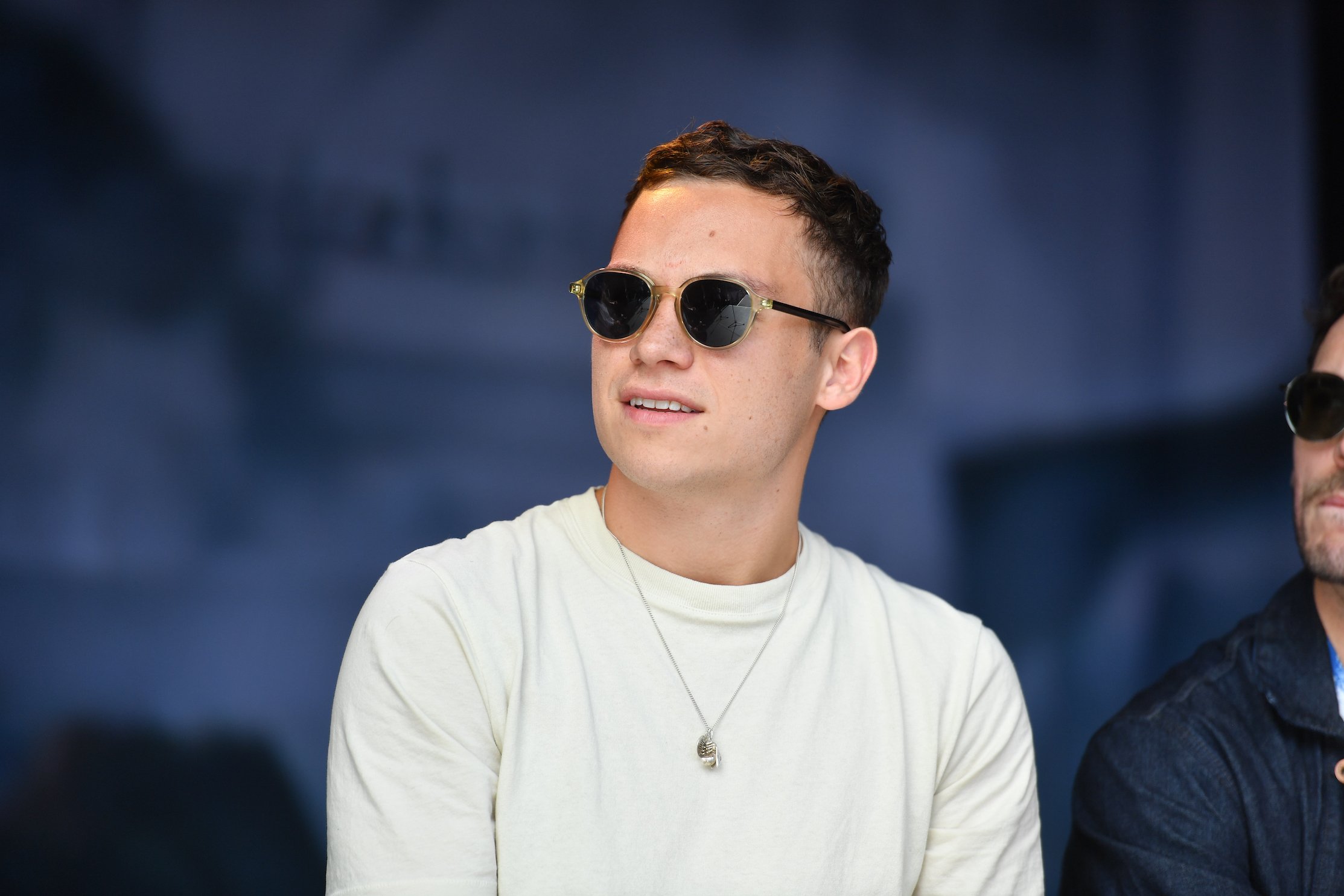 Finn Cole, Michael Gray in 'Peaky Blinders' Season 6, wearing sunglasses at a 'Peaky Blinders' festival in Birmingham