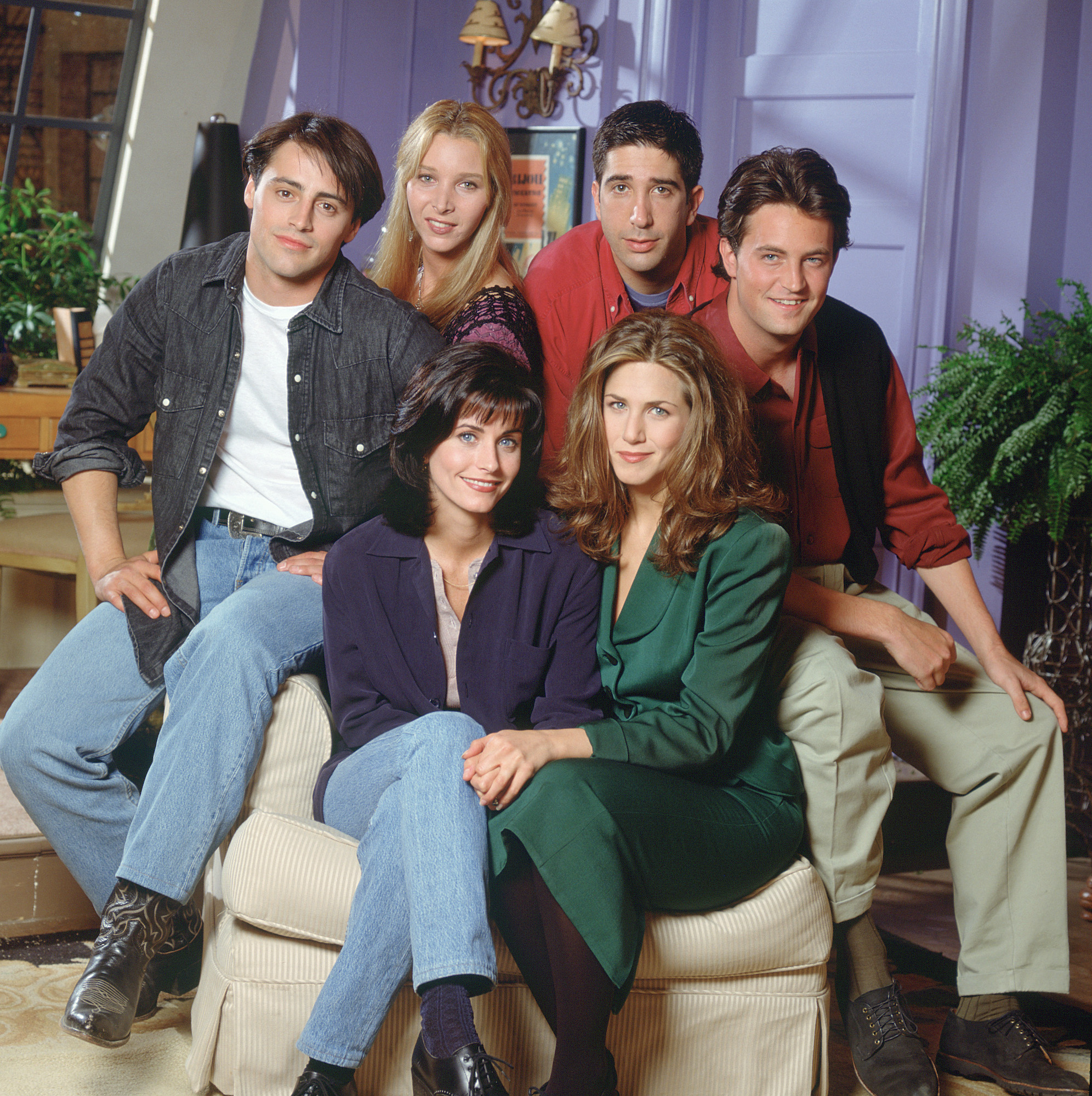 Friends cast sitting in Monica Geller's apartment on a couch