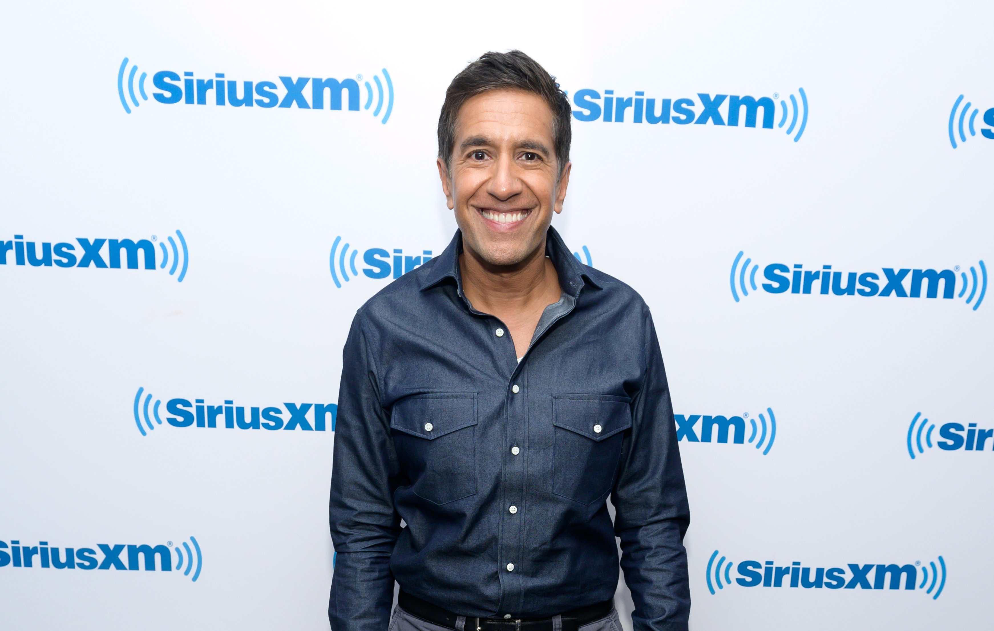 Dr. Sanjay Gupta, CNN's Chief Medical Correspondent smiles for the camera as he appears at a SiriusXM event.
