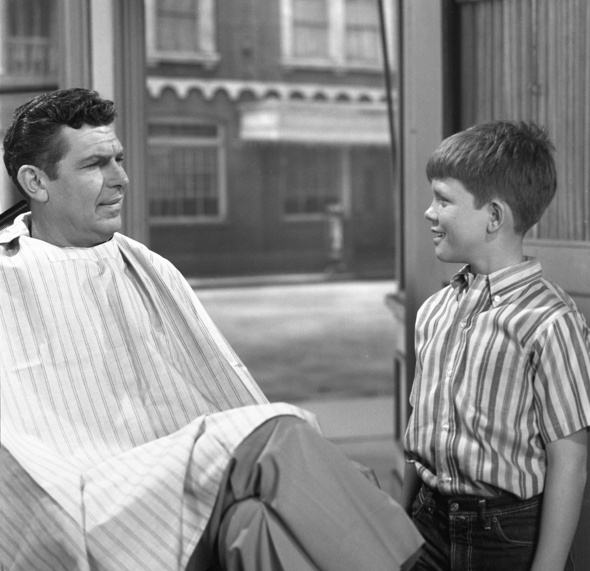 Actors Andy Griffith and Ron Howard chat in Floyd's barbershop in a scene from 'The Andy Griffith Show'