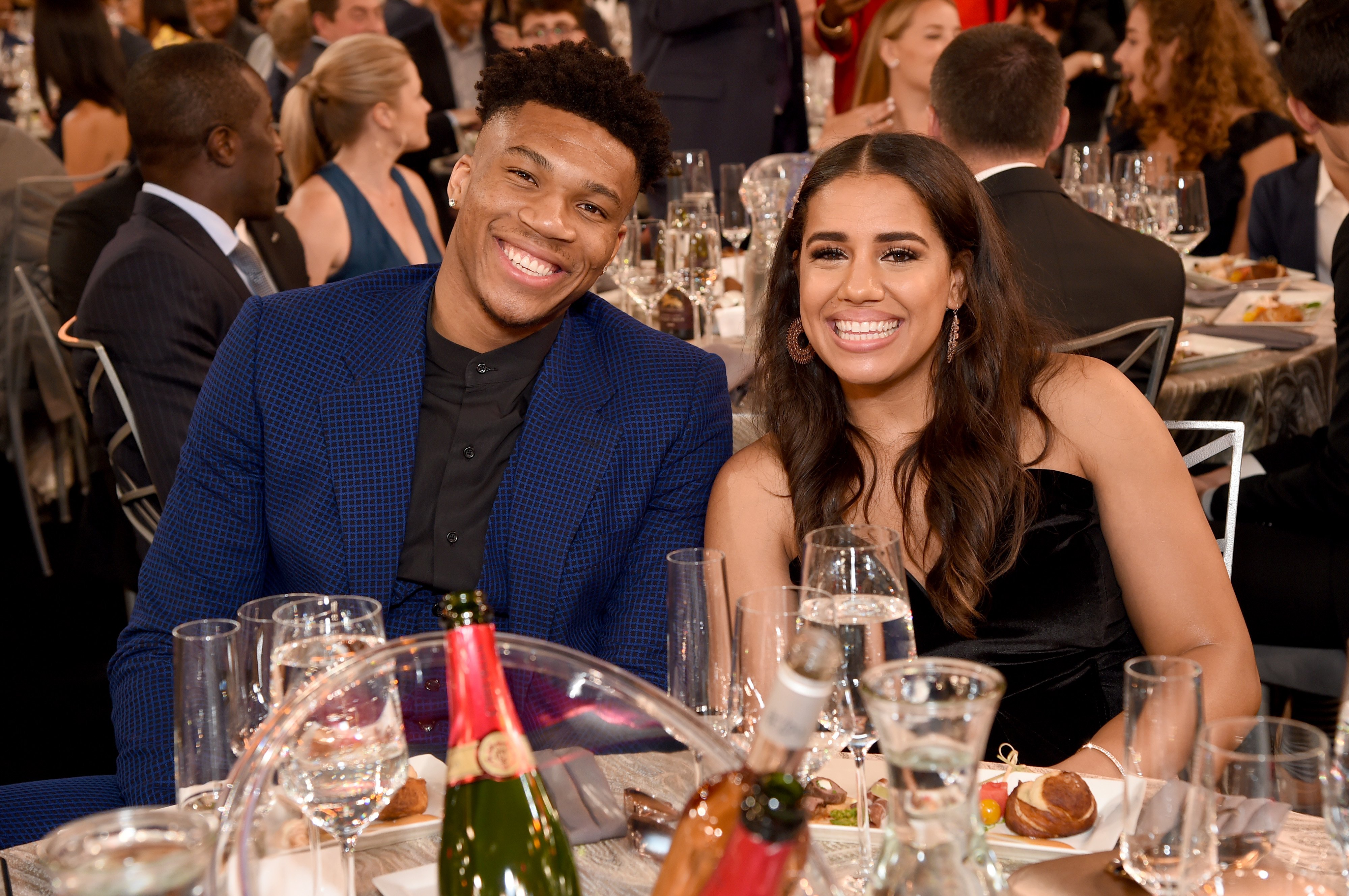 Giannis Antetokounmpo and Mariah Riddlesprigger sitting together and posing for a photo at the 2019 NBA Awards